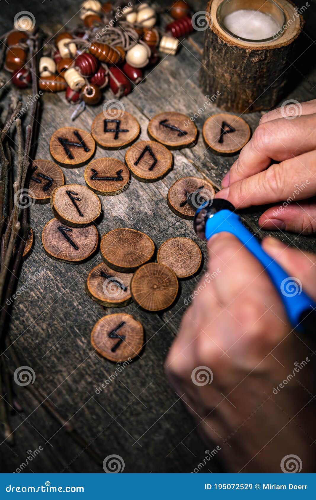 man writing wooden runes with an pyrography or pokerwork, esoteric background