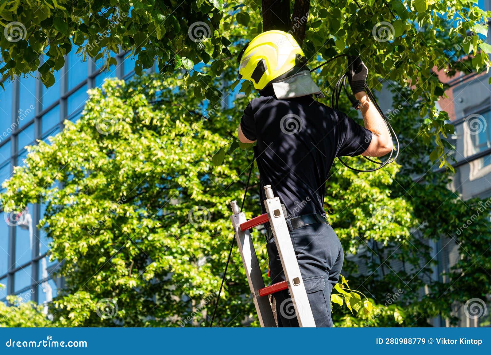 A Man in a Yellow Helmet Pulls the Wire while Standing on a Mobile