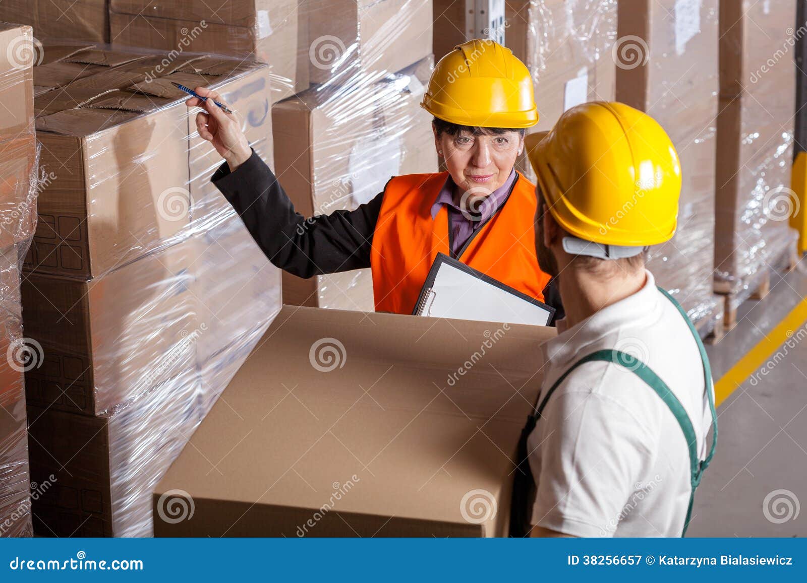manager giving worker instruction in warehouse