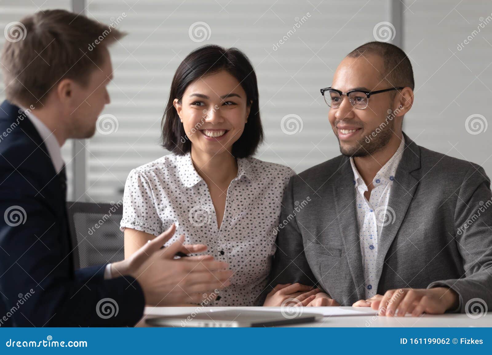 manager realtor banker consulting happy diverse young couple at meeting