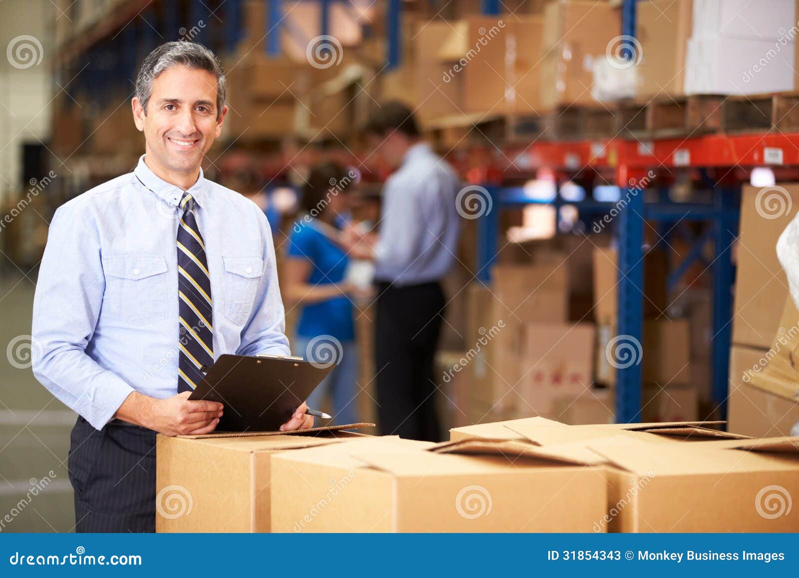 manager in warehouse checking boxes