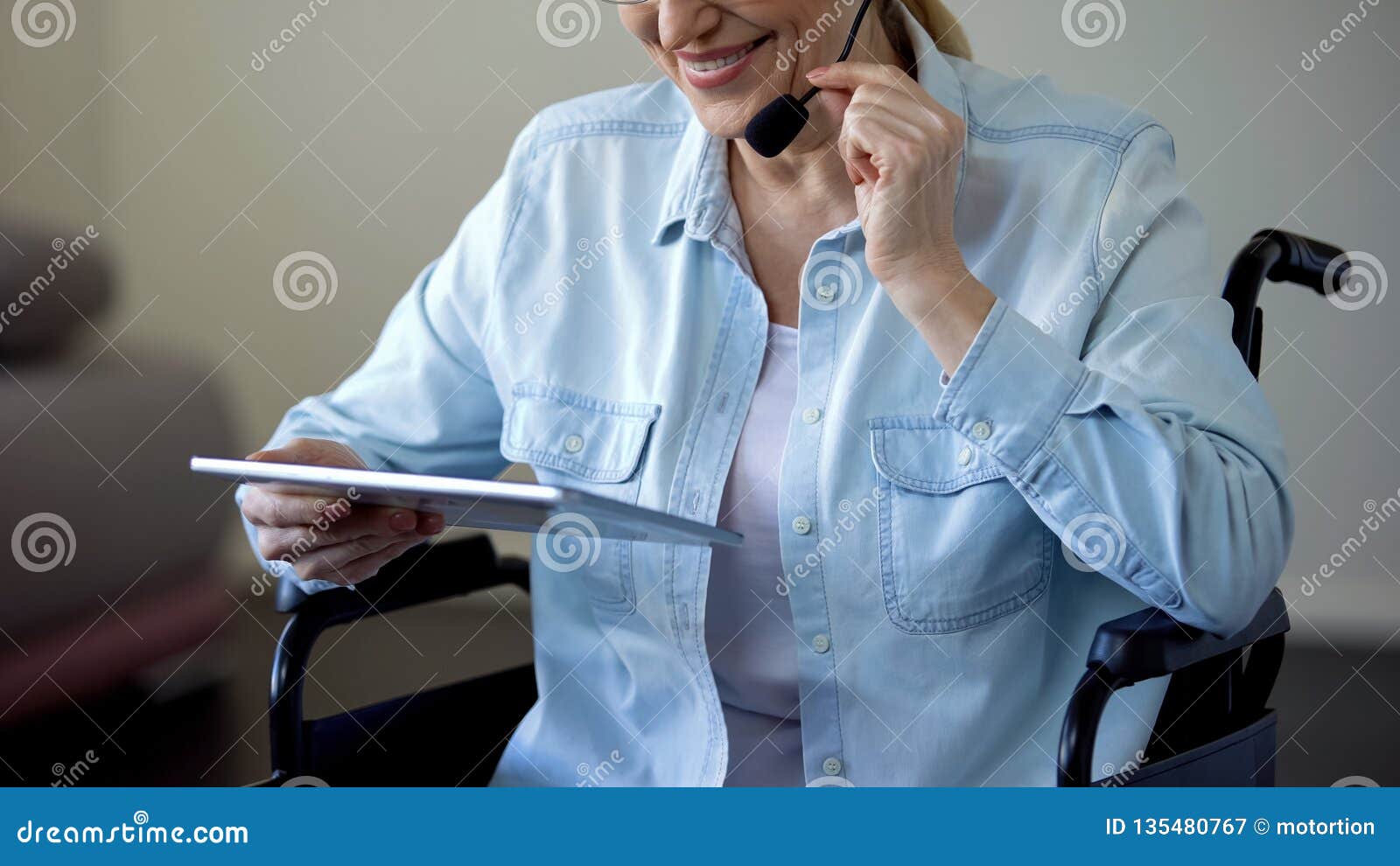 Manager in Wheelchair with Headset Talking with Client and Working on