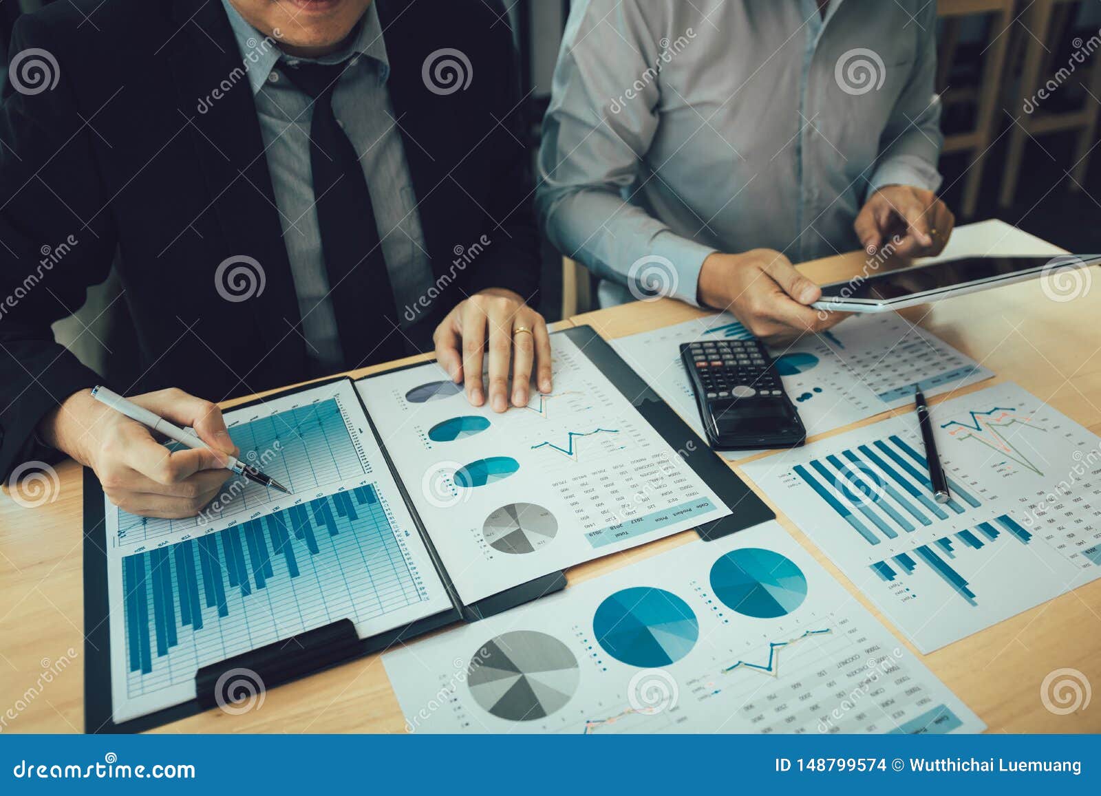 managers are using tablets to analyze sales cost reports and explain summary reports to employees calculate and record summary
