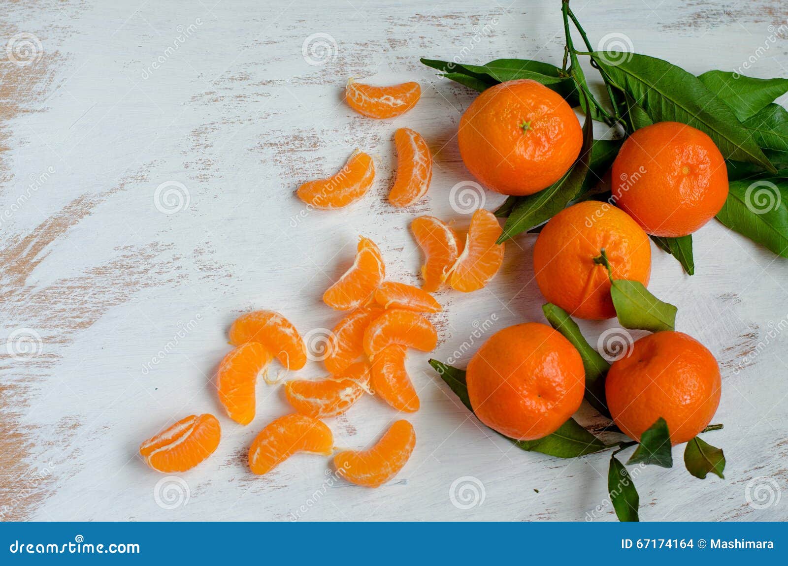 Mandarinas maduras en el fondo blanco. Las mandarinas y las rebanadas maduras de la mandarina en un blanco pintaron al tablero