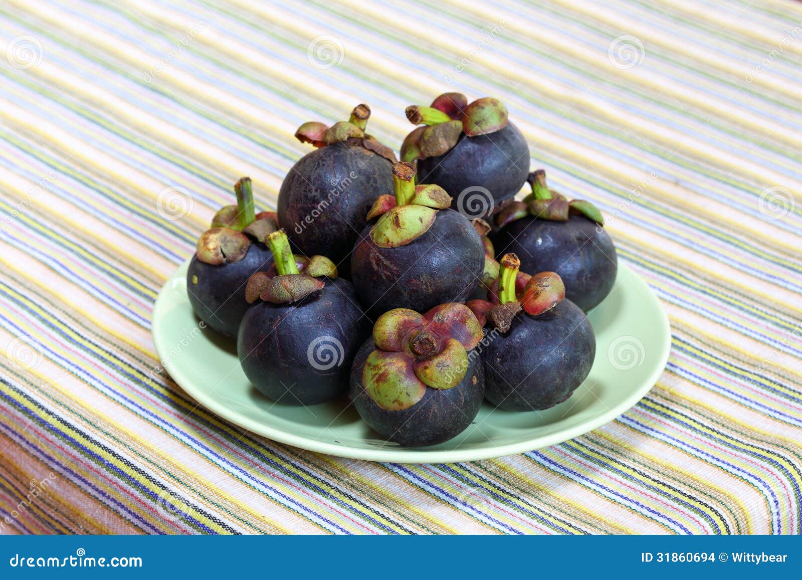 A Mangosteen on green dish stock photo. Image of juicy 31860694