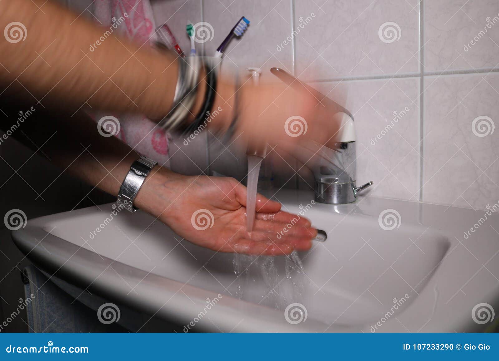 Mani di lavaggio dell'uomo in un lavandino. Giovani mani caucasiche di lavaggio dell'uomo nella fine del lavandino della toilette su