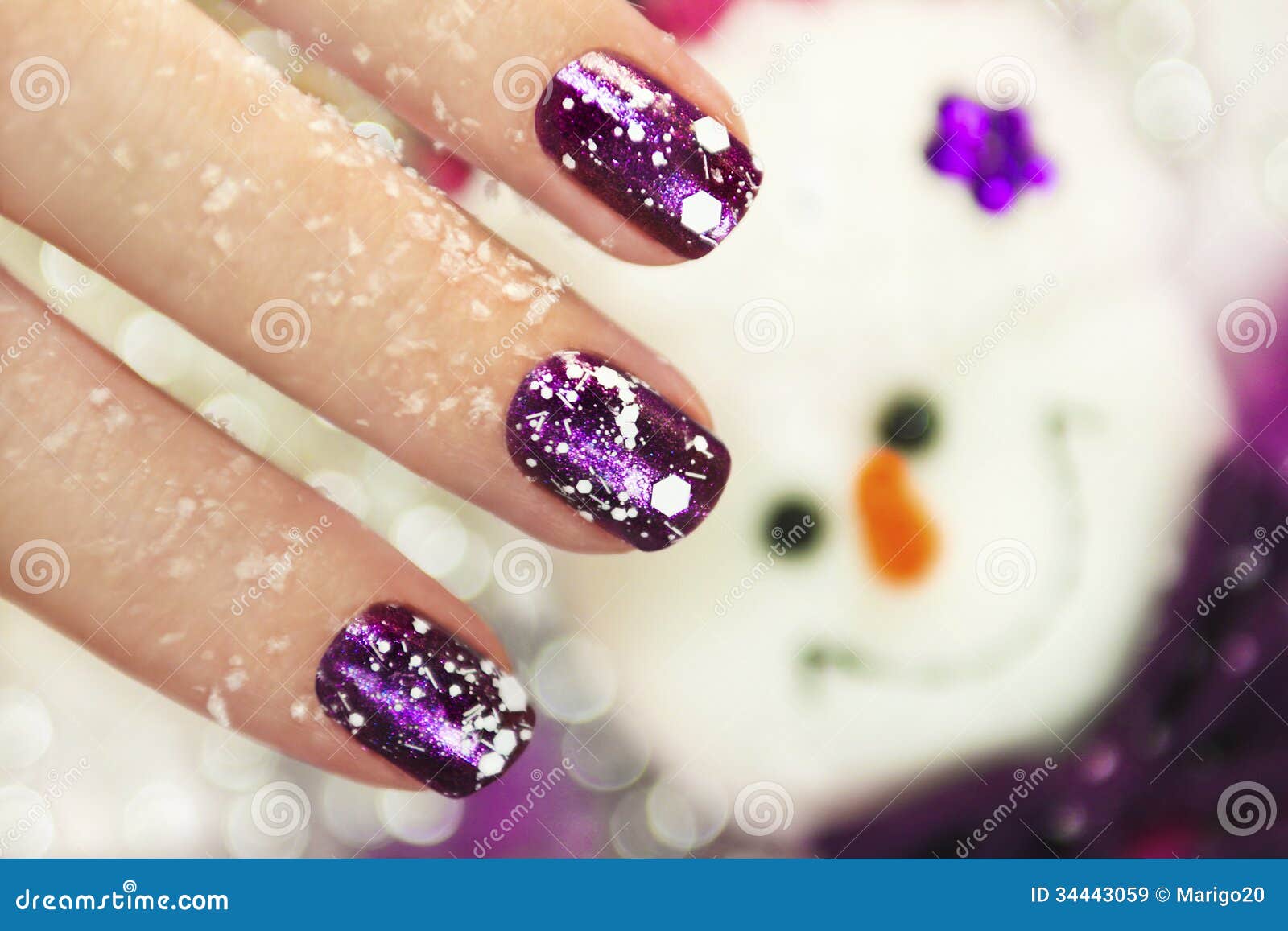 Manicure di inverno. Manicure di inverno del nuovo anno di Natale con la progettazione dei fiocchi di neve bianchi su vernice brillante viola per le unghie sui precedenti del pupazzo di neve.