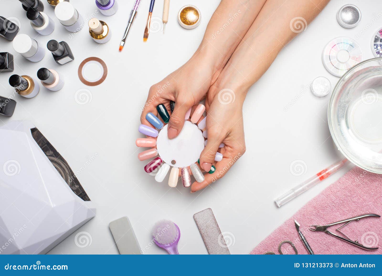 manicure - the girl herself does, watching the nails with the help of a tool on a white background. concept of beauty salons and n