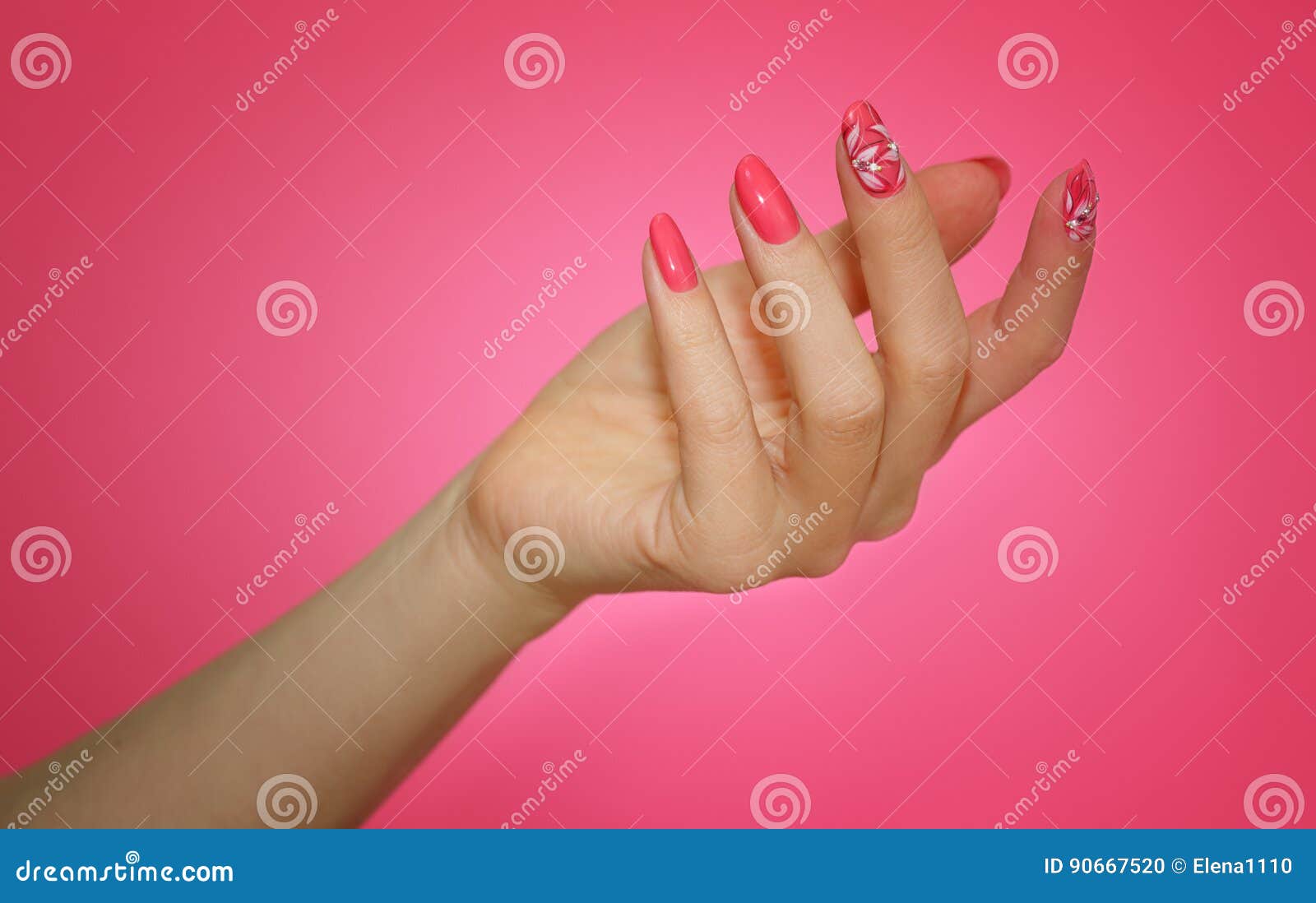 manicured woman`s nails with pink nailart with flowers.