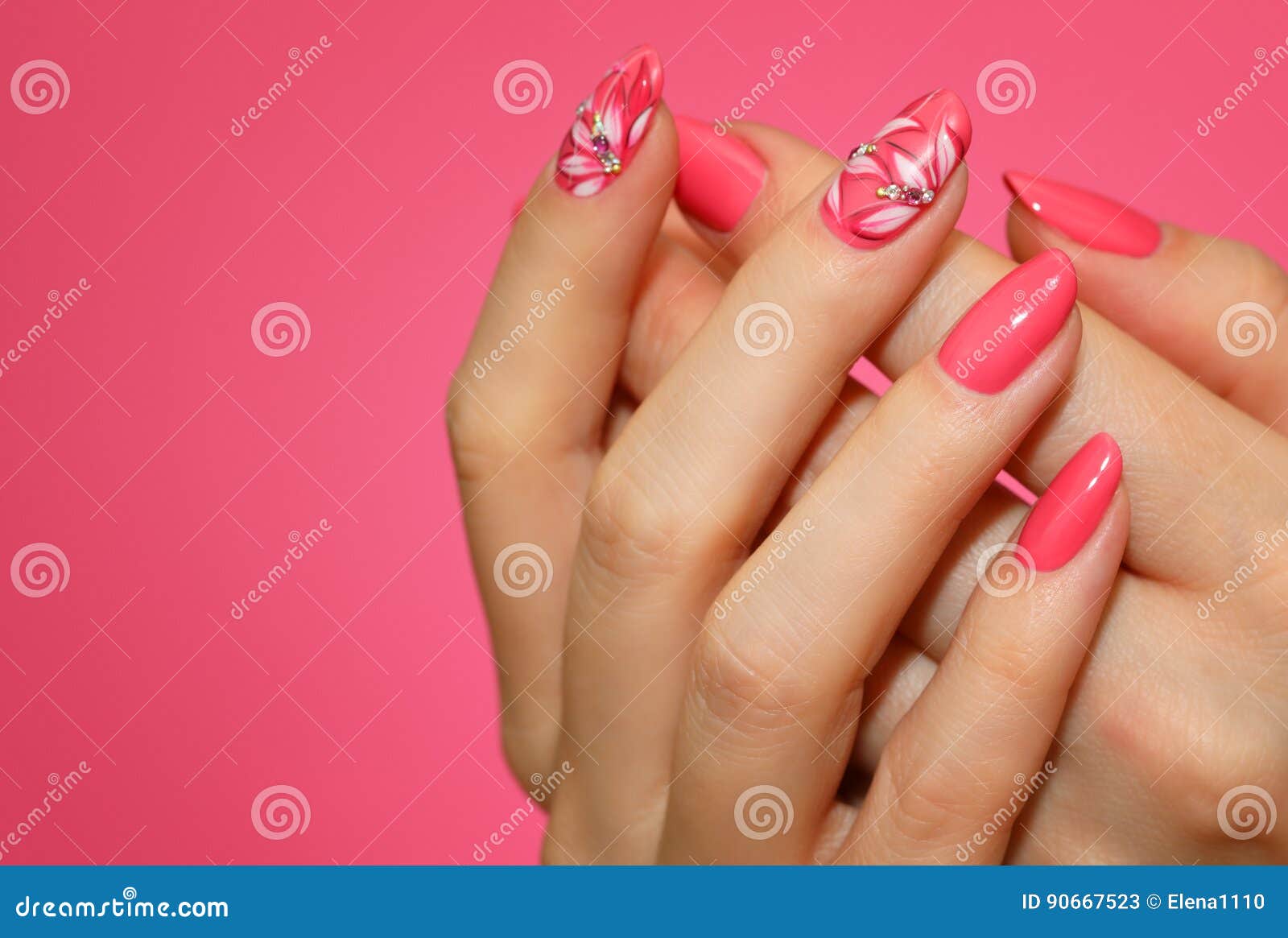 manicured woman`s nails with pink nailart with flowers.