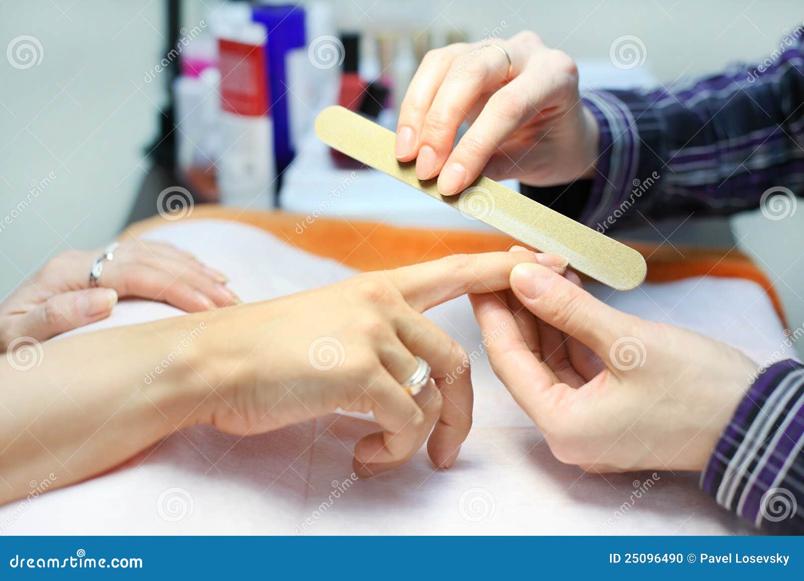 manicurist hands make manicure by nailfile