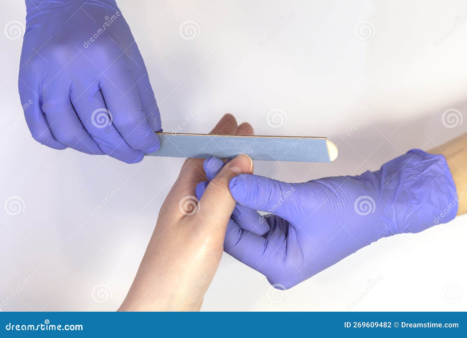 manicurist s, files beautiful woman's nails, holding finger. caucasian manicure