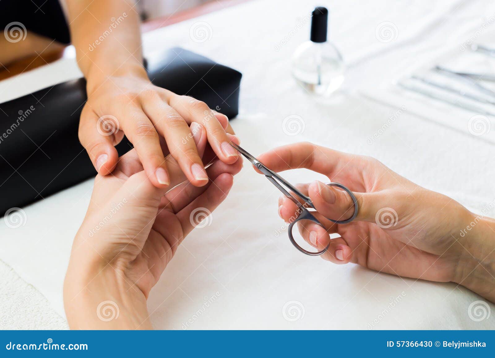 manicurist trimming a clients cuticles
