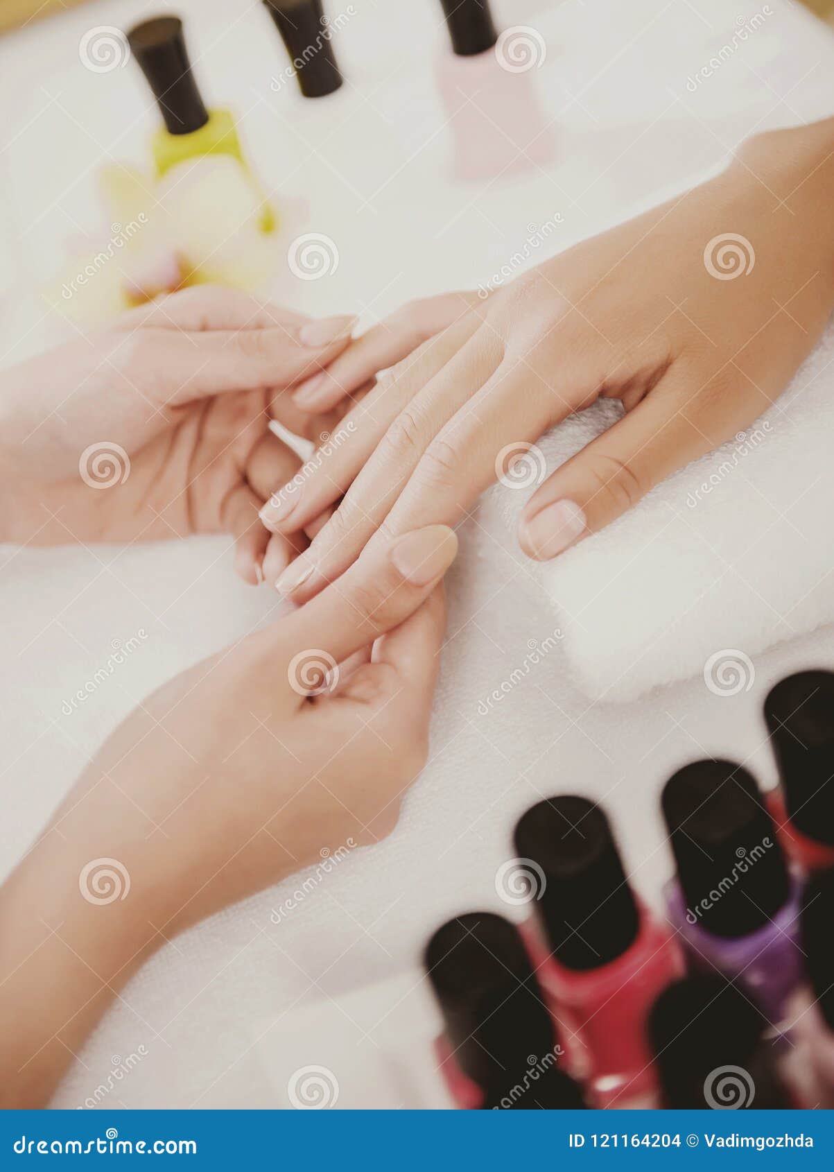 manicurist works with clients in beauty salon.