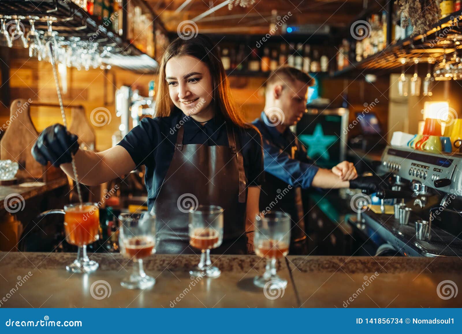 Manlig och kvinnlig bartender på stångräknaren Alkoholdrinkförberedelse Två barmans som arbetar i bar