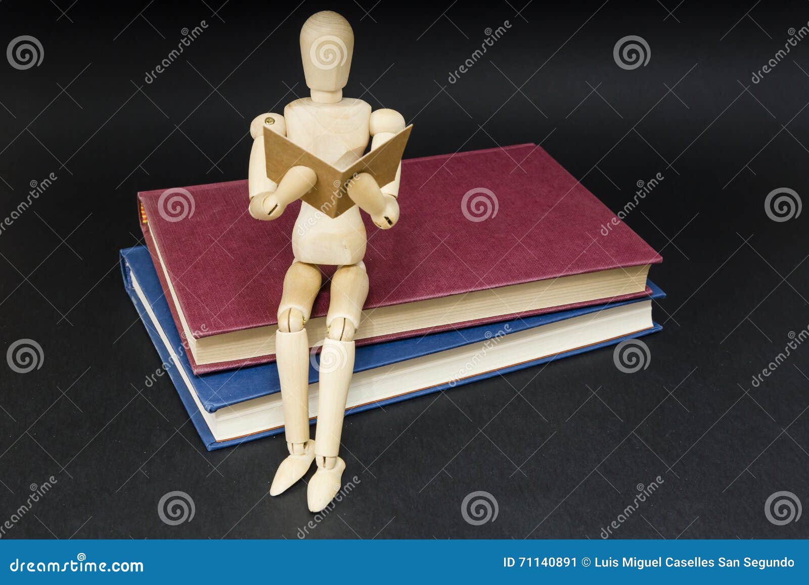 mannequin sitting on two books reading