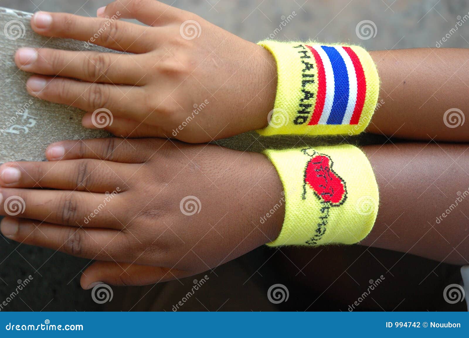 Mano dei bambini con il wristband della Tailandia. Al banco, i bambini sono wristband da portare pazzesco della Tailandia e wristband che dice l'amore di i il re, Surat Thani, Tailandia.