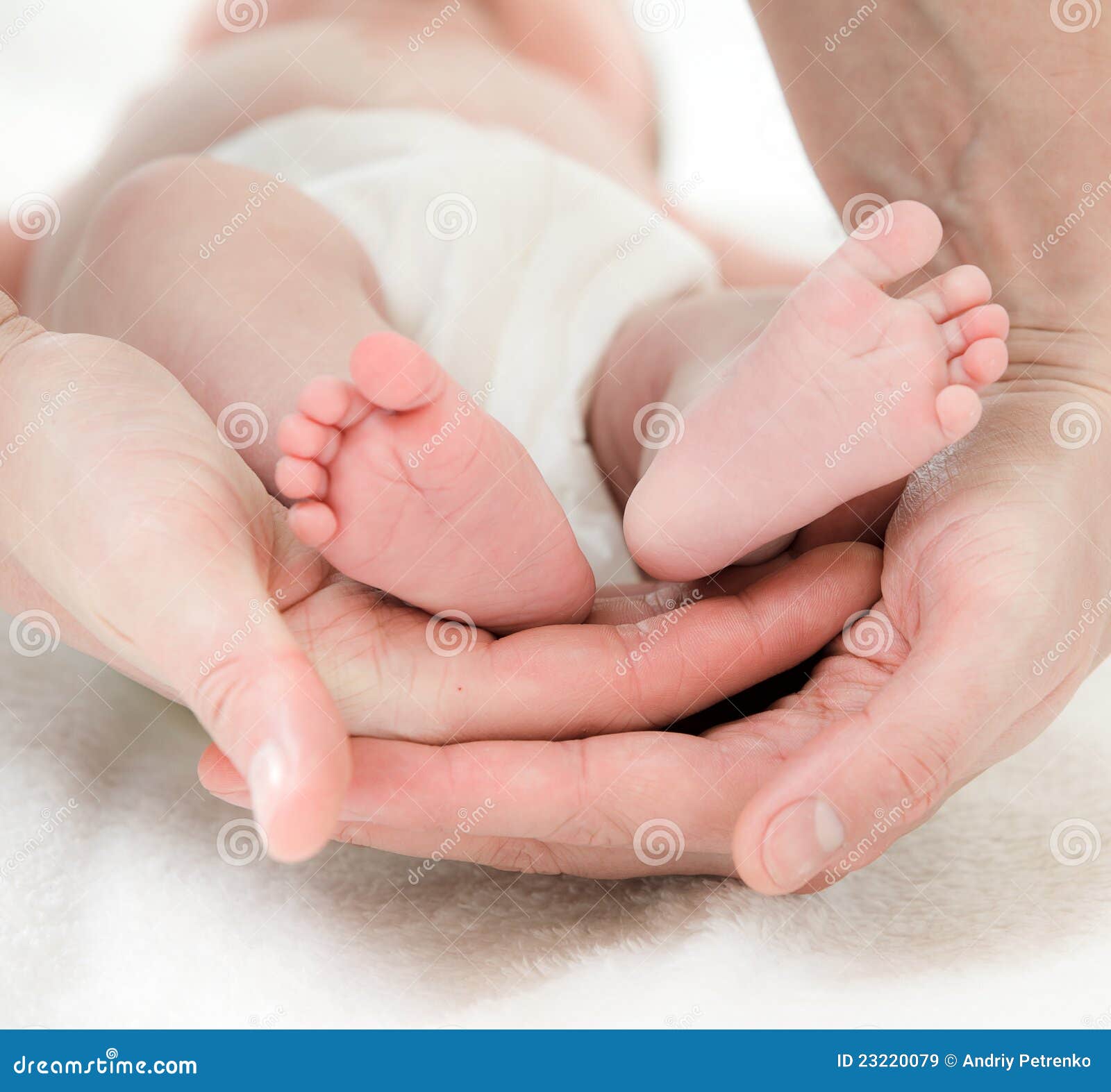 Mano del padre e piedi dei bambini. Chiuda in su della mano del padre e dei piedi dei bambini