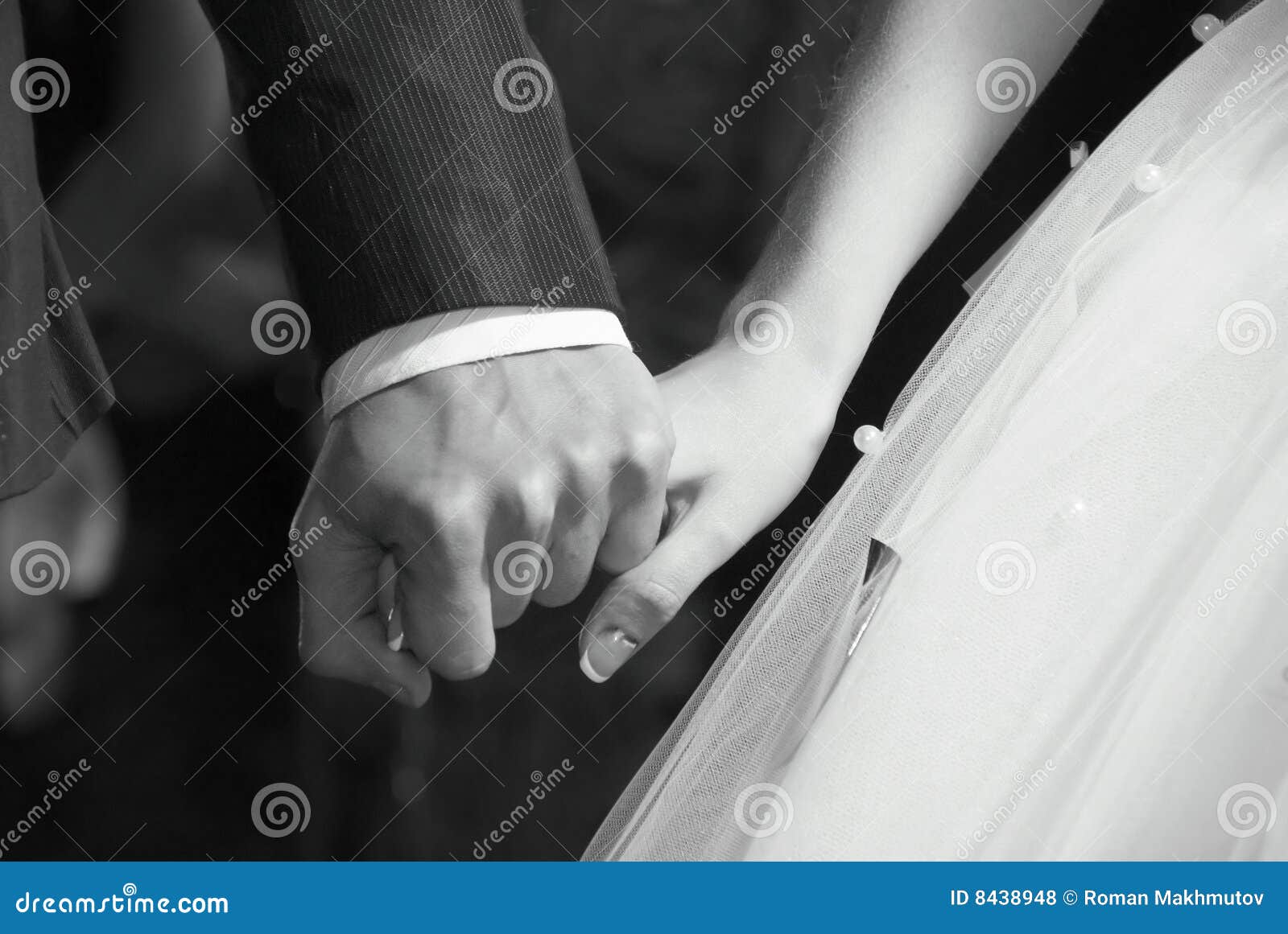 Mano della sposa in mano dello sposo. Foto romantica in bianco e nero della sposa e dello sposo congiuntamente alla cerimonia di cerimonia nuziale.