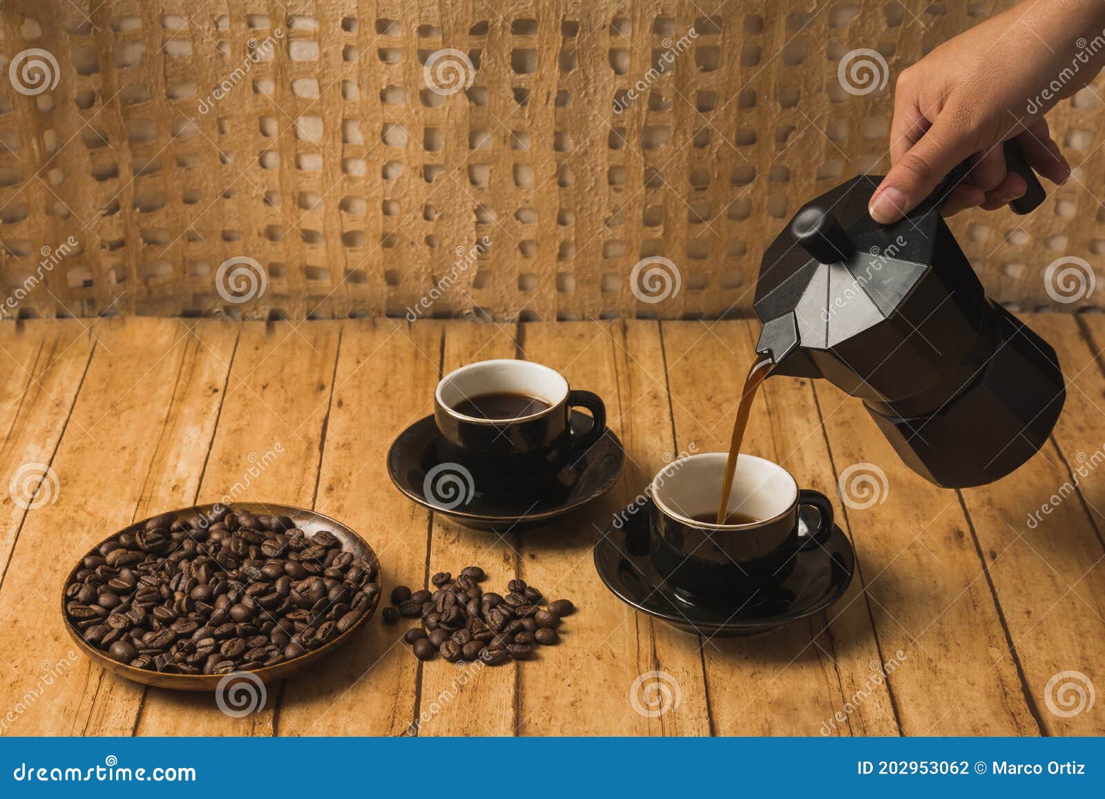 cafetera italiana y una taza de café con granos de café tostados en un  recipiente de madera 10841144 Foto de stock en Vecteezy
