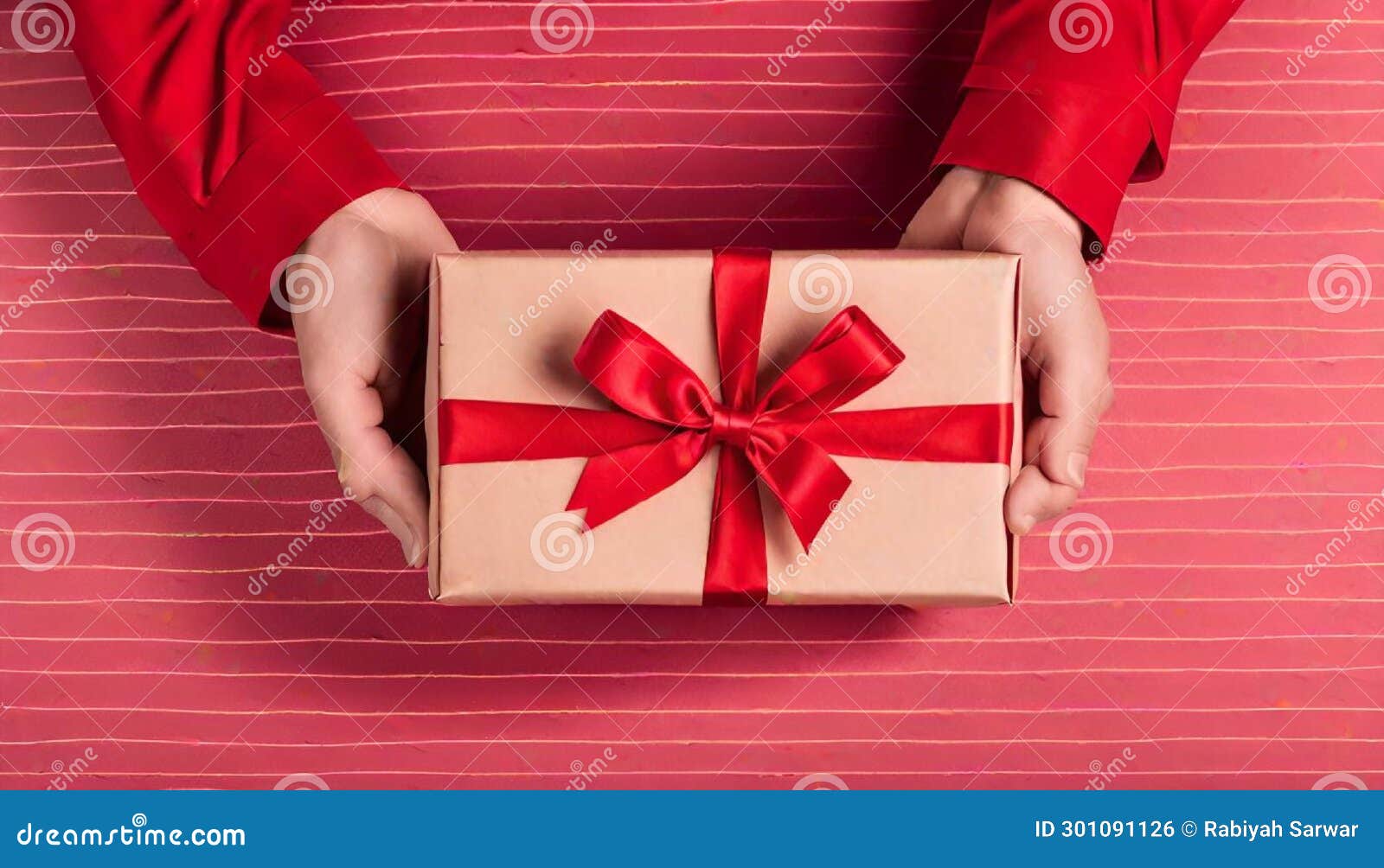 mano sosteniendo una caja de regalo roja con lazo escarlata sobre fondo carmesÃ­