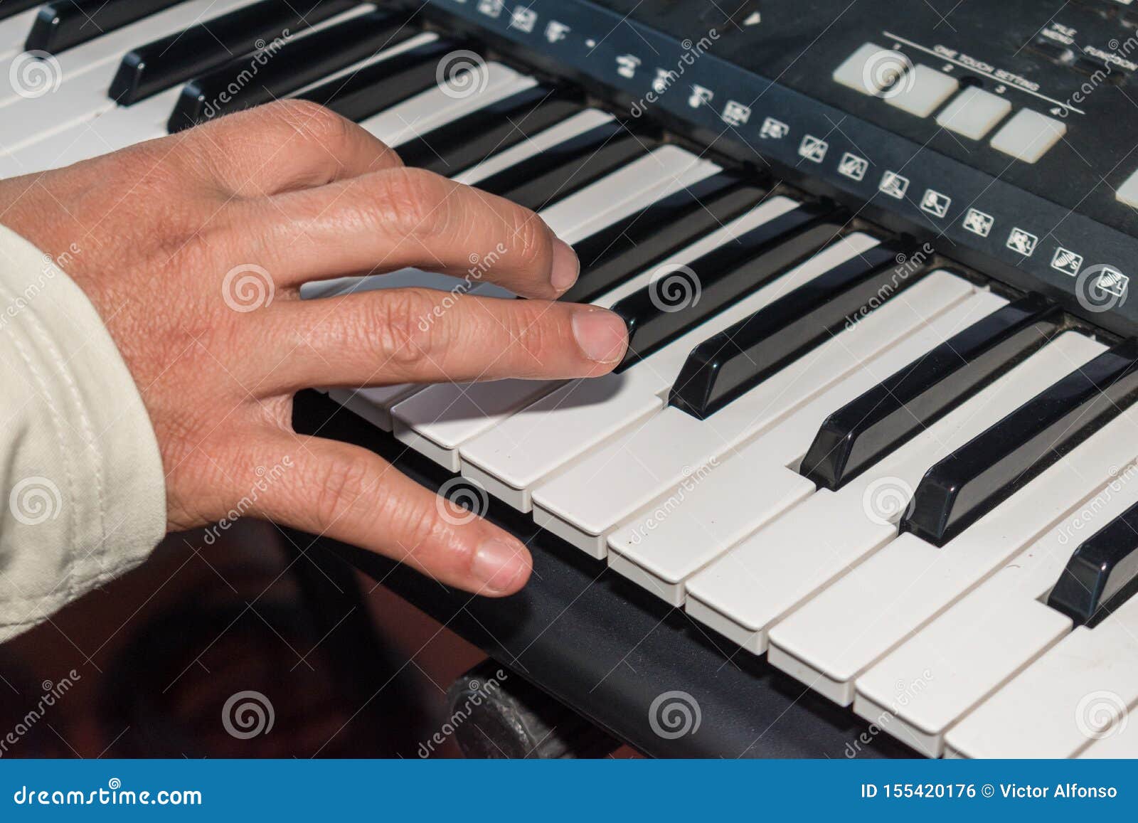 manos de hombre tocando piano