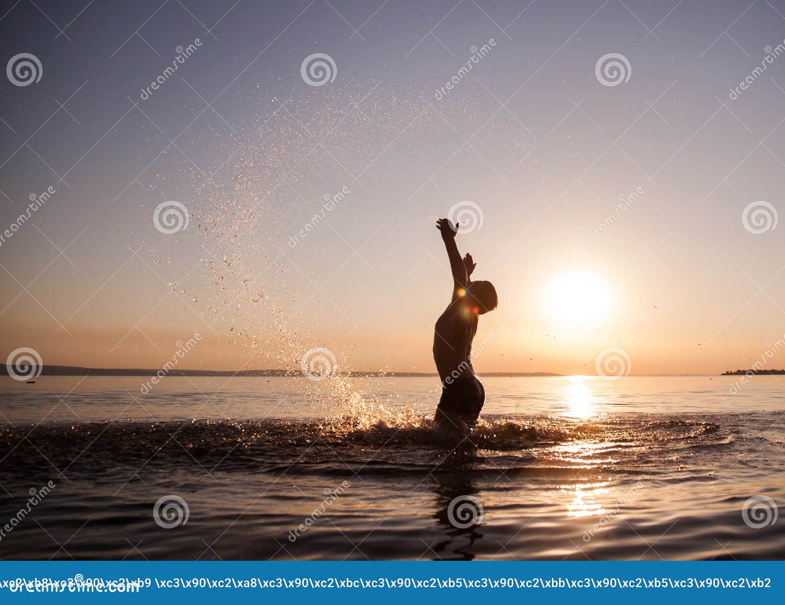 Manos de las emociones del muchacho en la puesta del sol en agua