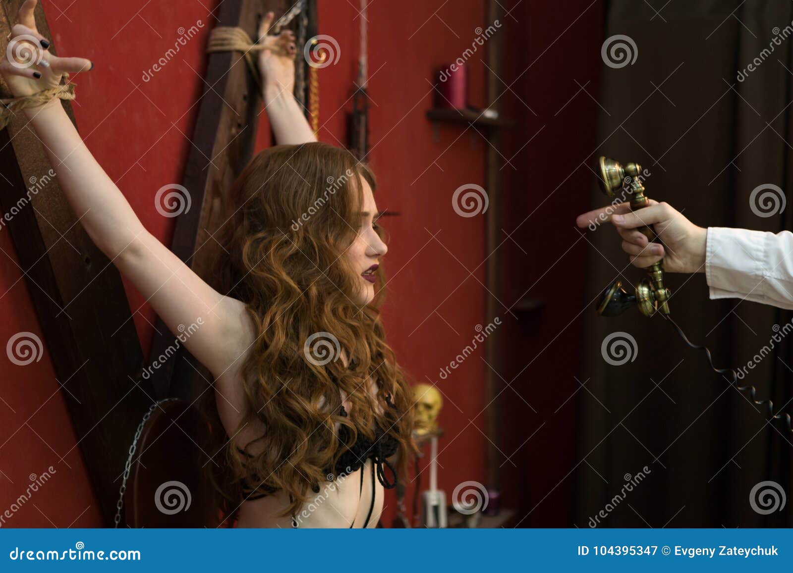 Mans Hand Handling Retro Phone At Roped Girl In Lingerie Bondage To Red