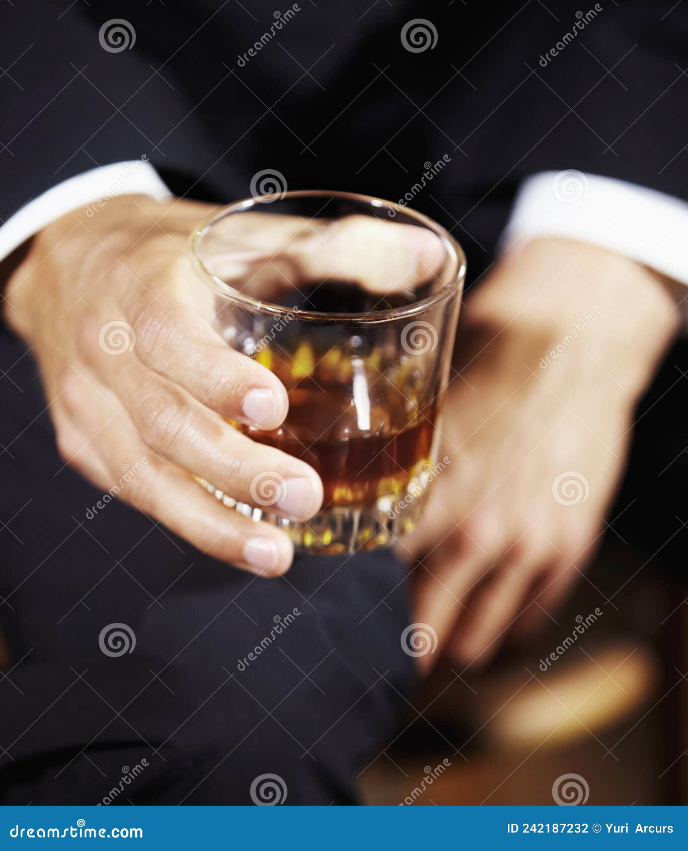 Its a Mans World. Mans Hand Holding a Whiskey Glass Balanced on His