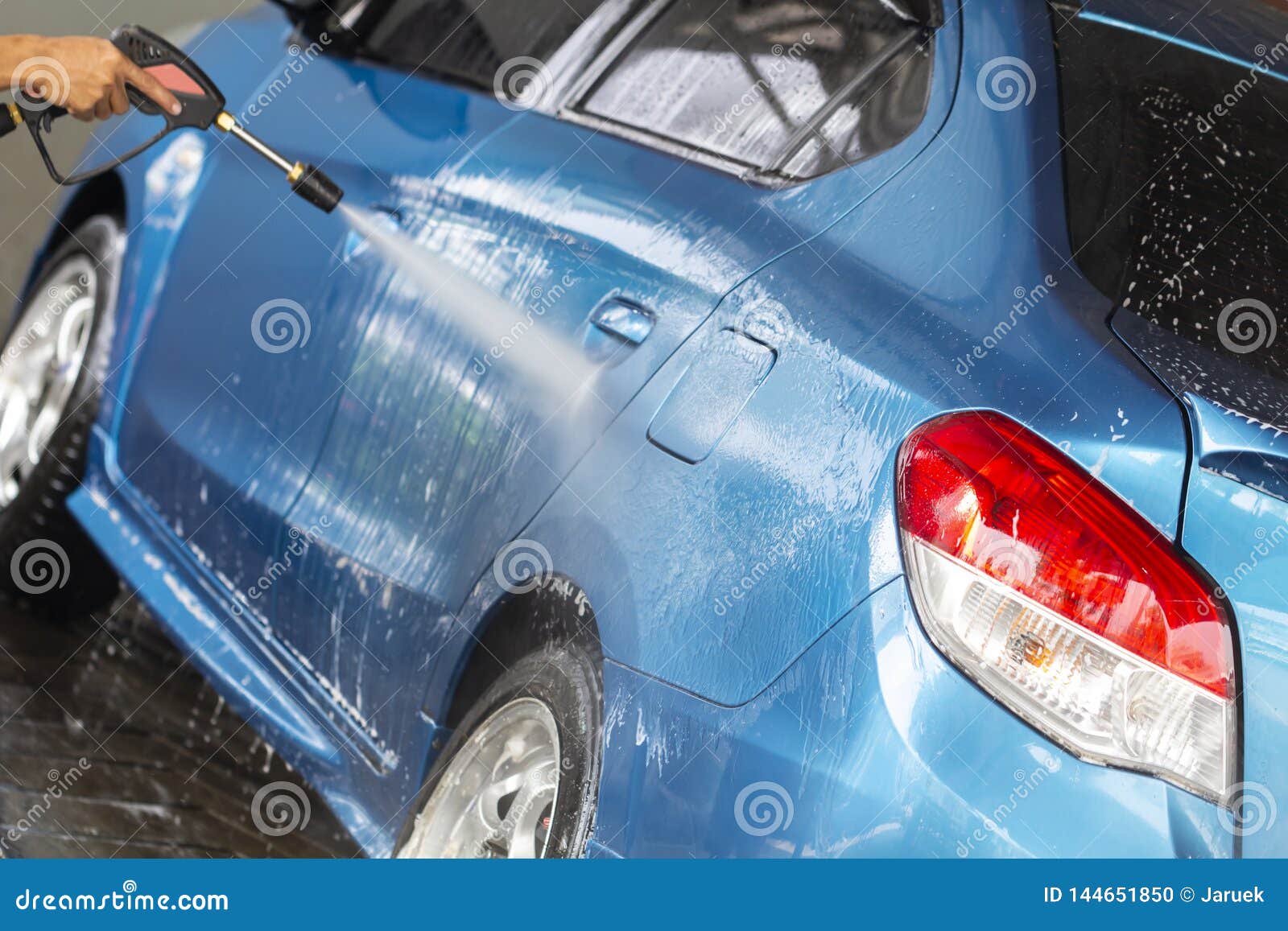 Manual Car Wash With Pressurized Water In Car Wash Outside