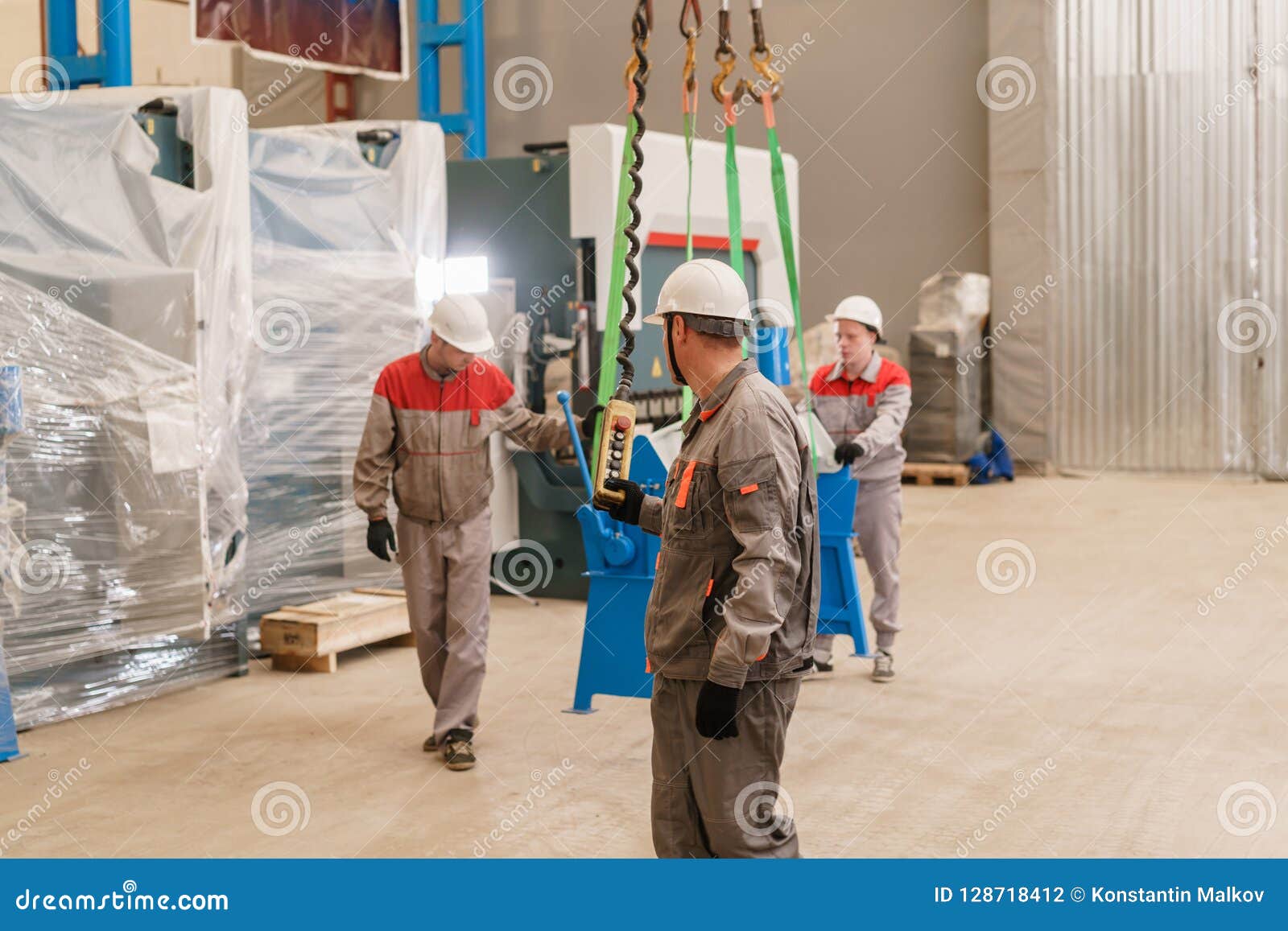 manufacture workshop. move the crane with beam. workers adjusts the machine in the warehouse. the production of