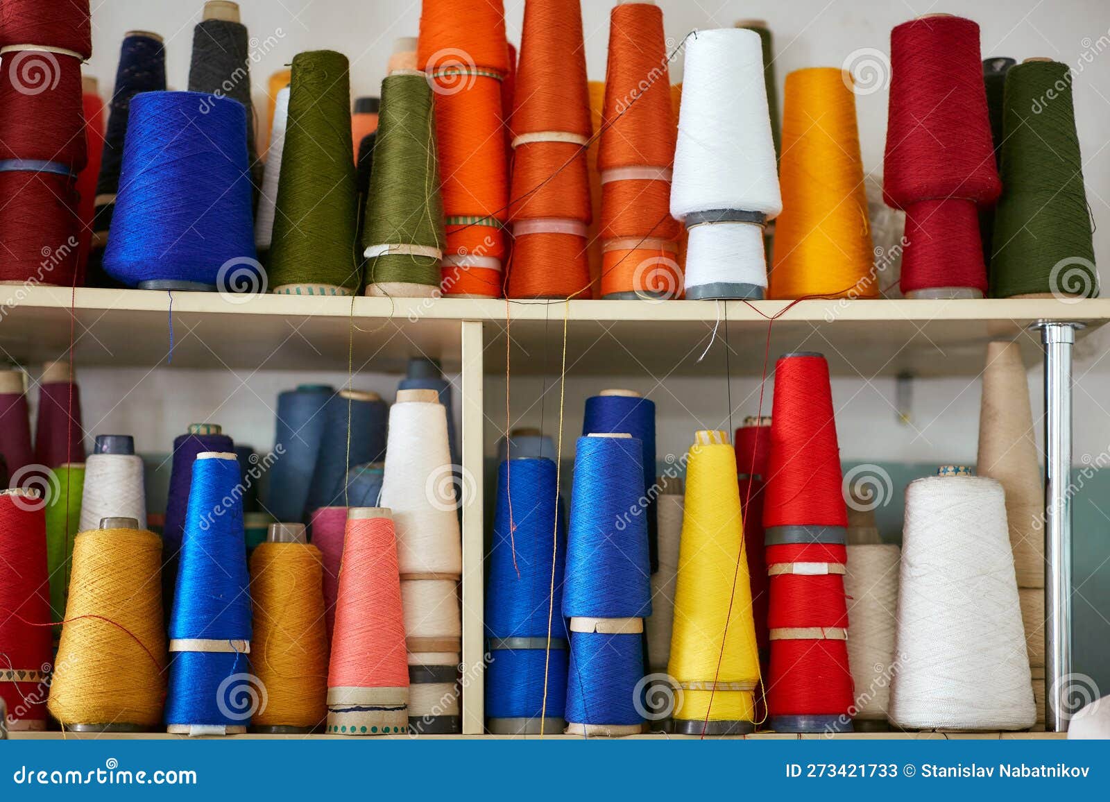 Bobbins with Knitting Threads Stand in a Row on a Rack Stock Image