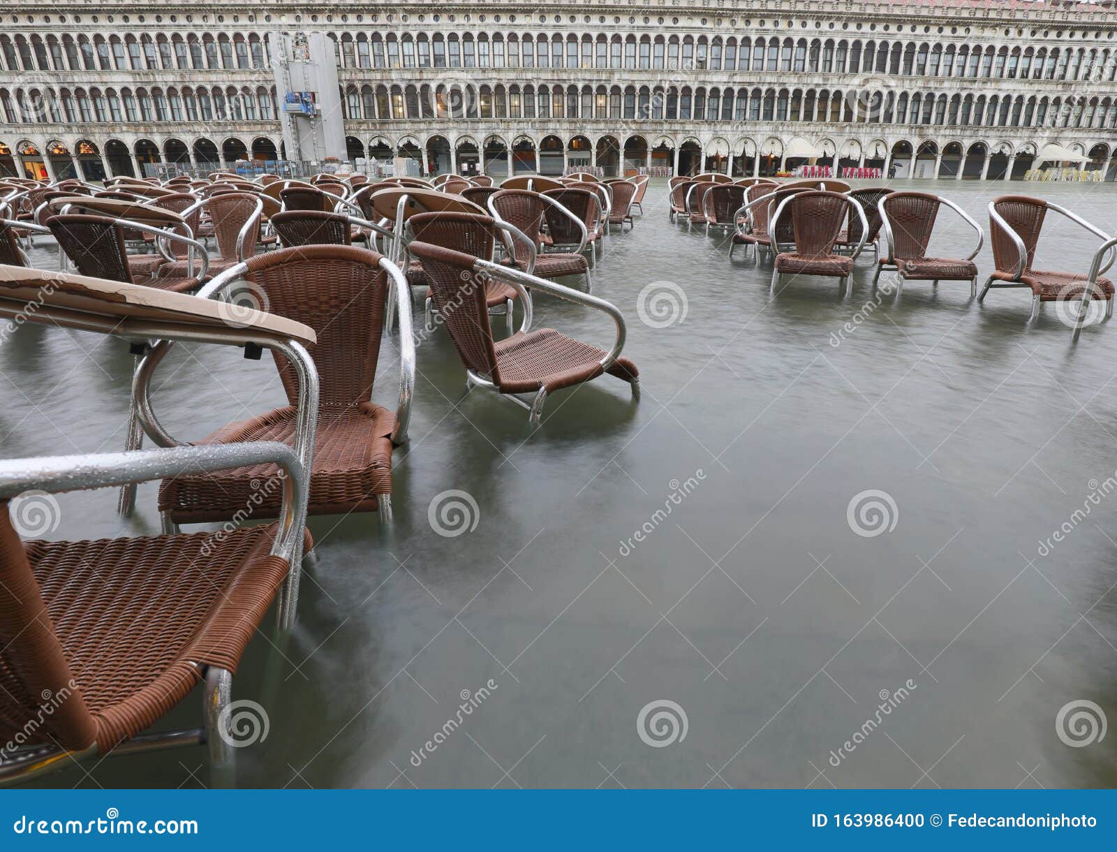 many brown chairs on the water during the record high tide in ve