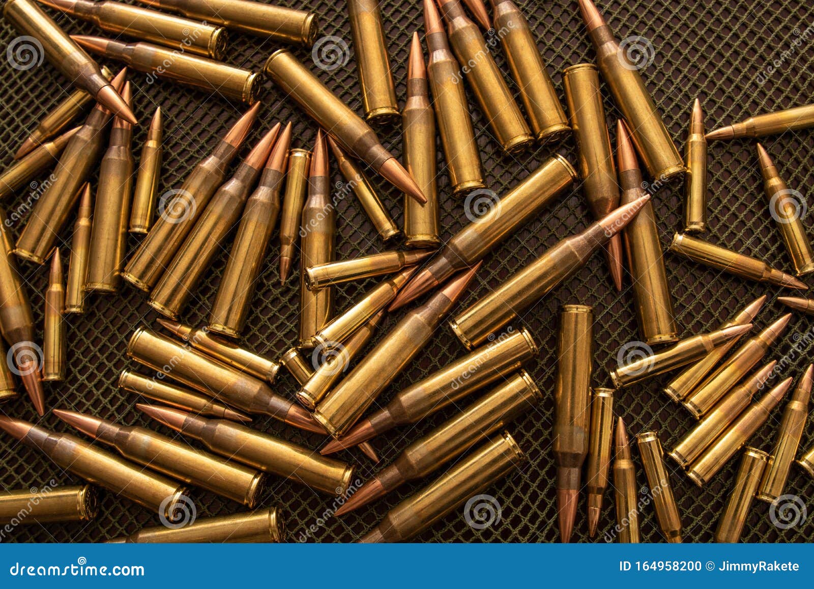 many bullets calibre .338 and .223 on a table with a green net