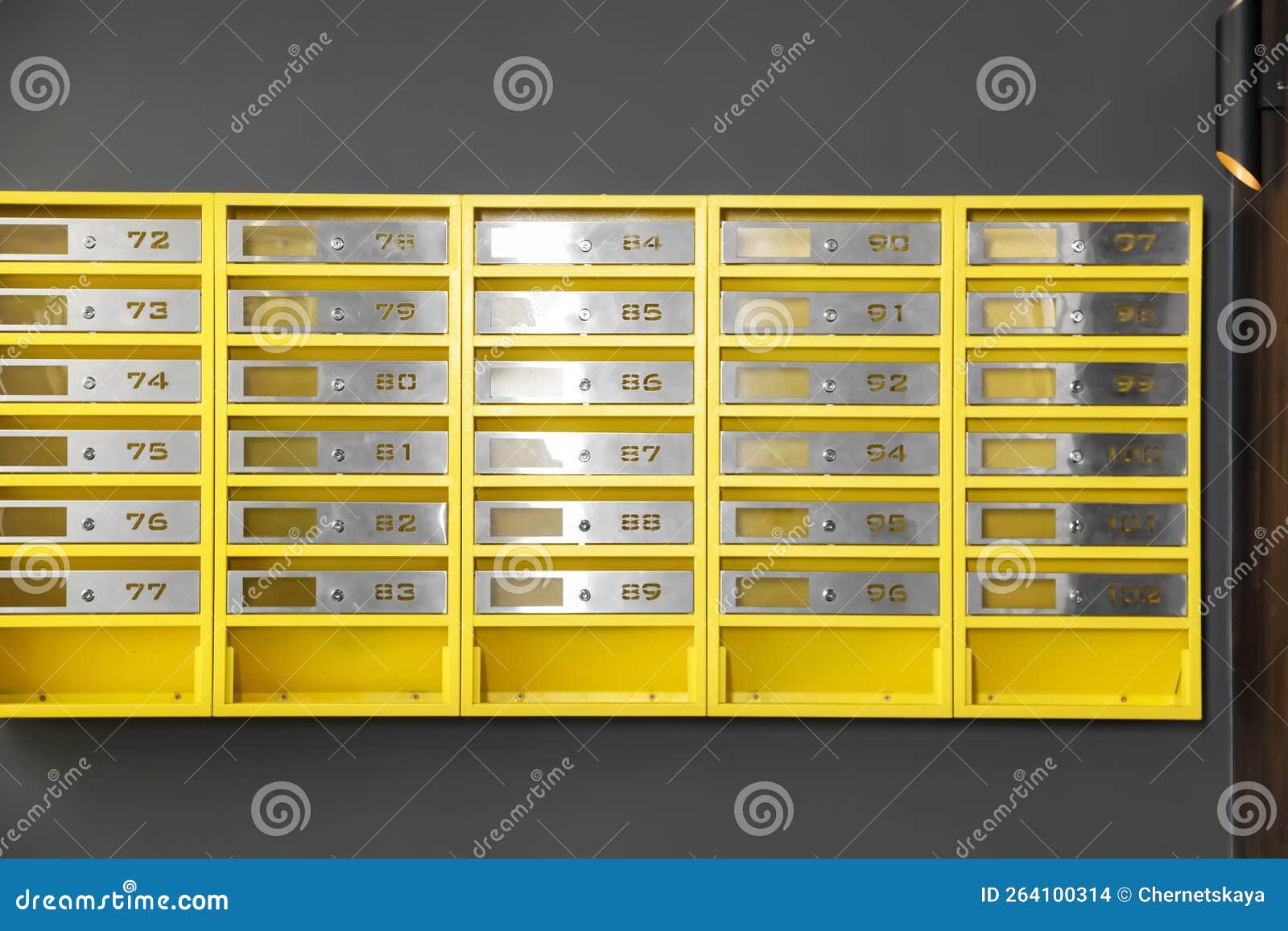 Many Closed Metal Mailboxes with Keyholes and Numbers in Post Office