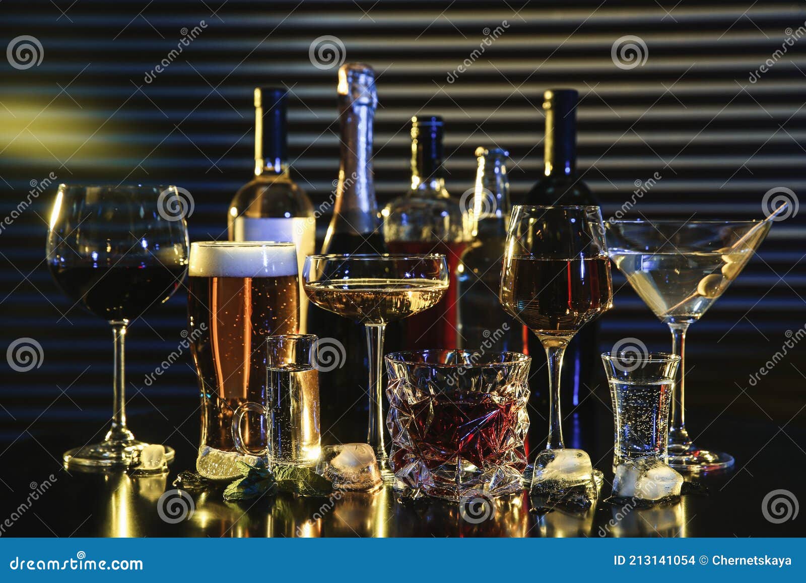 many different alcoholic drinks on table against dark background