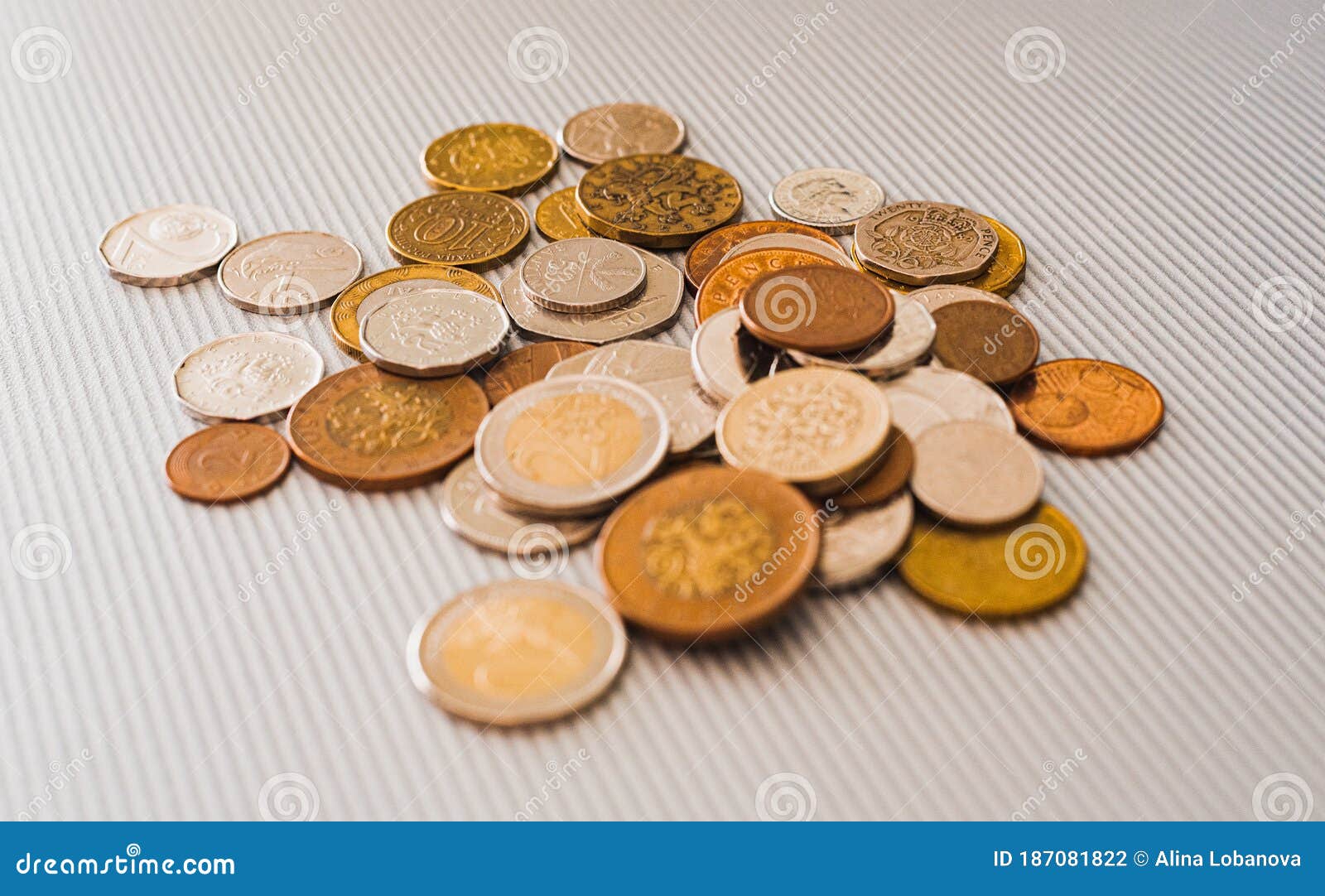 many different coins from different countries from the black wallet are scattered around the table: dollars, pounds, rubles, penni