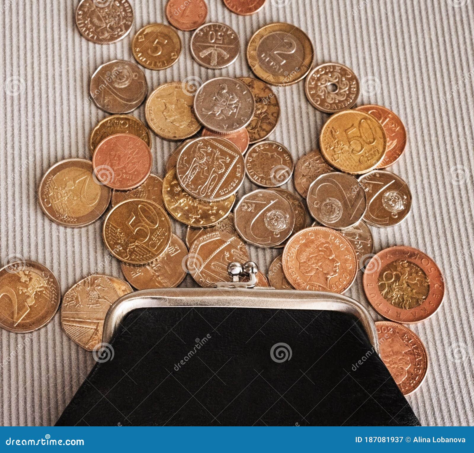 many different coins from different countries from the black wallet are scattered around the table: dollars, pounds, rubles, penni