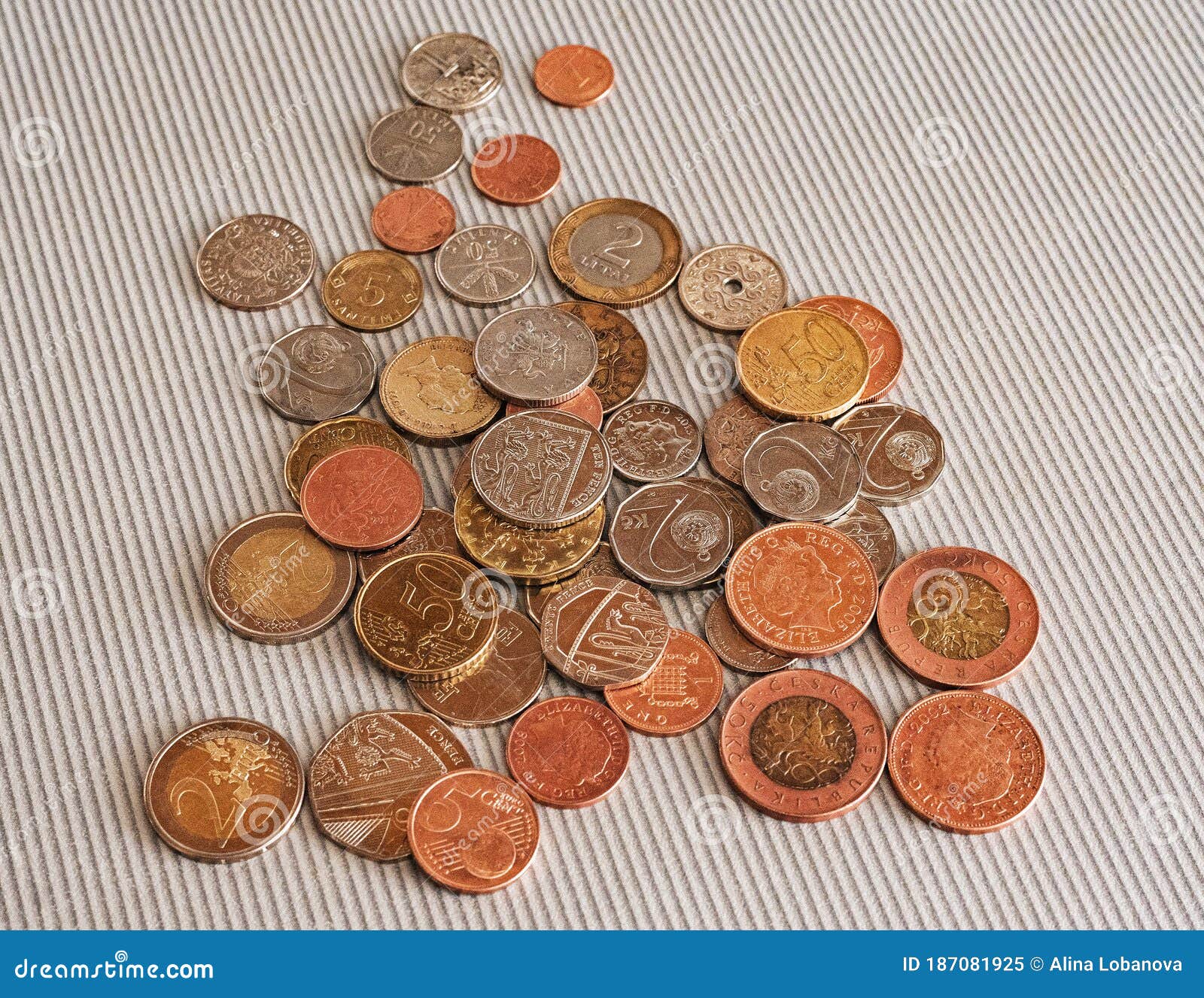 many different coins from different countries from the black wallet are scattered around the table: dollars, pounds, rubles, penni