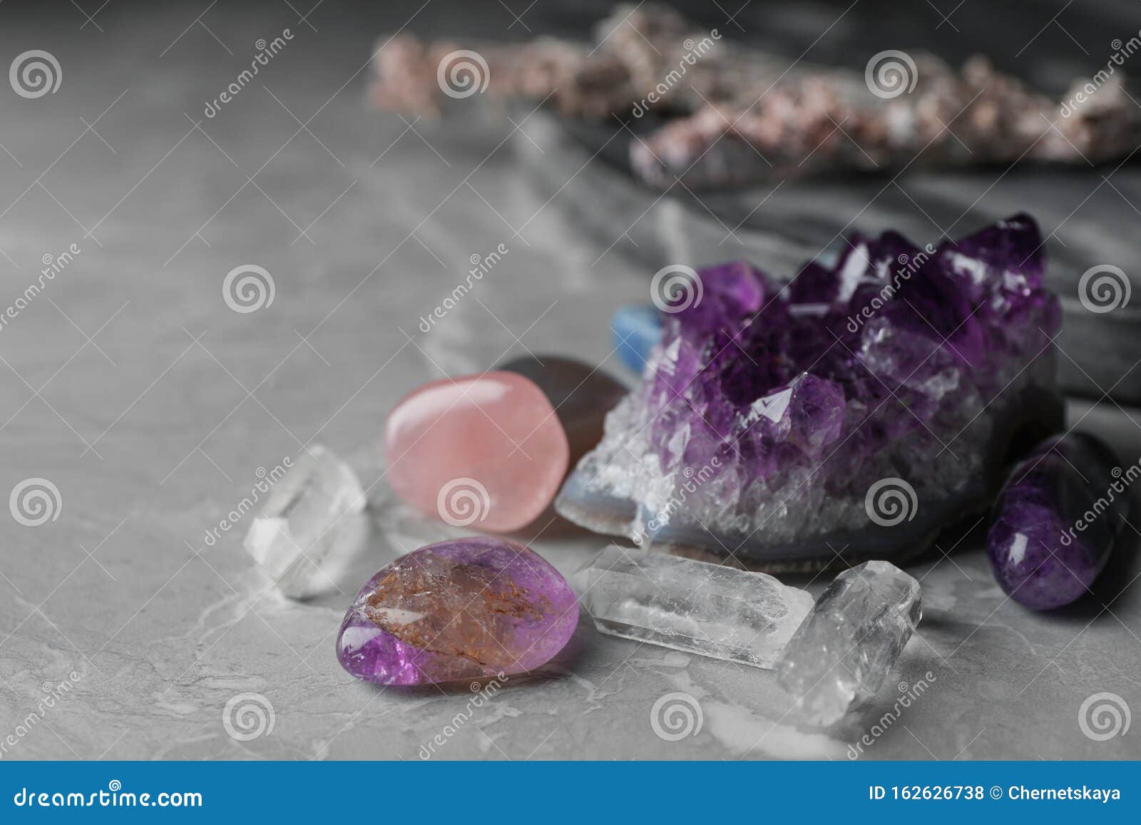 many different gemstones on marble table