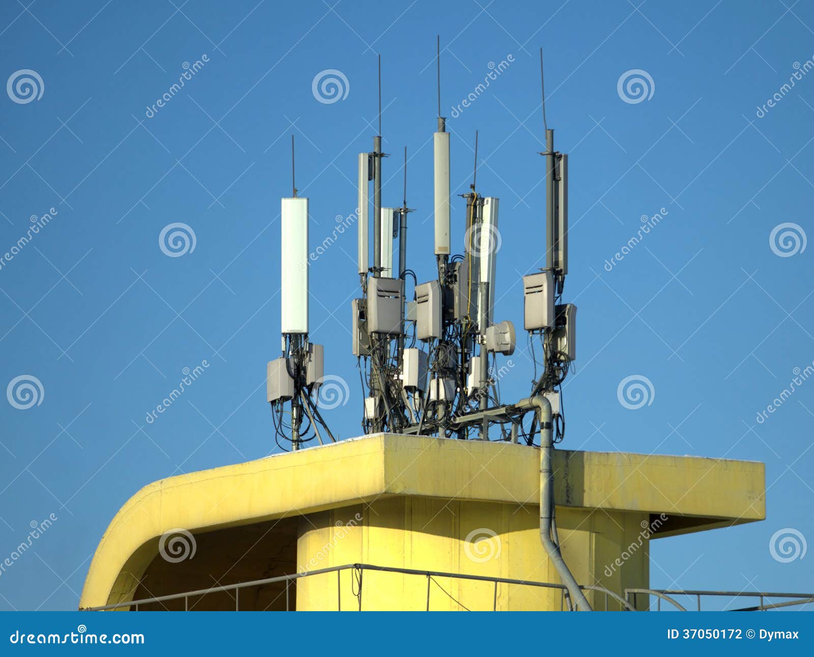 many electronics aerials on yellow building top