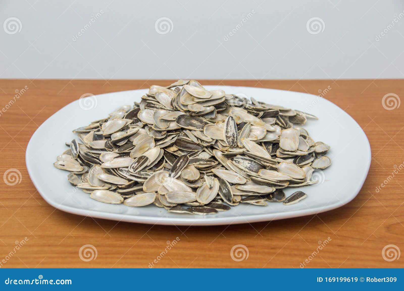 many empty shells of sunflower seeds on white plate