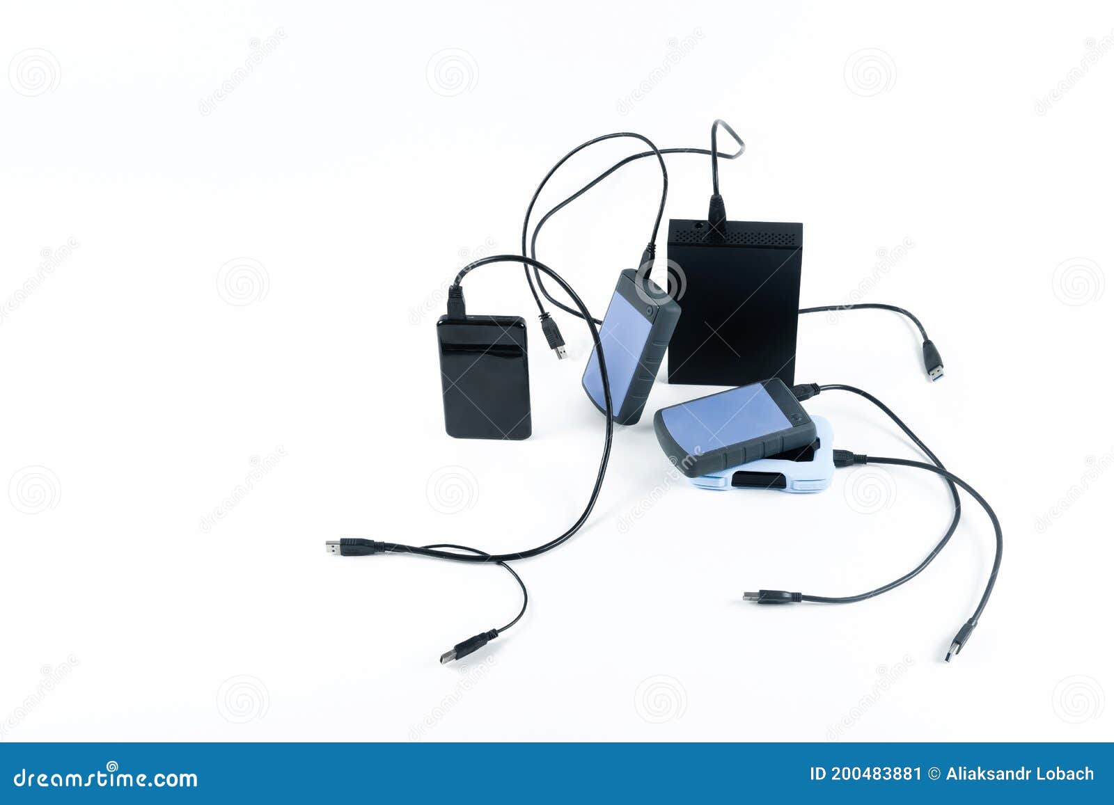 many external hard drives with wires lie on a white background. hard drives on isolate.