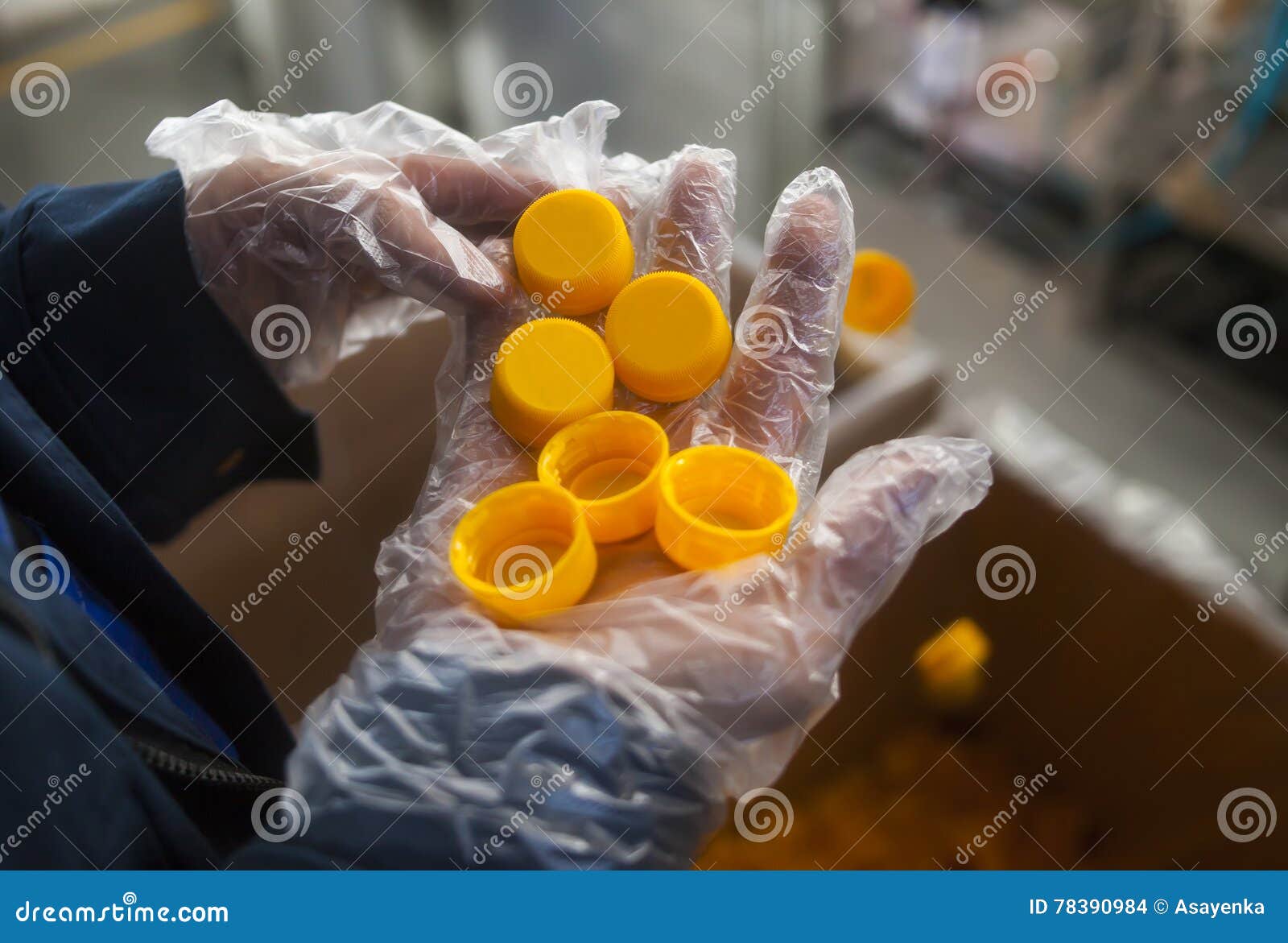 Many Orange Plastic Corks in the Hand in the Production Stock Photo