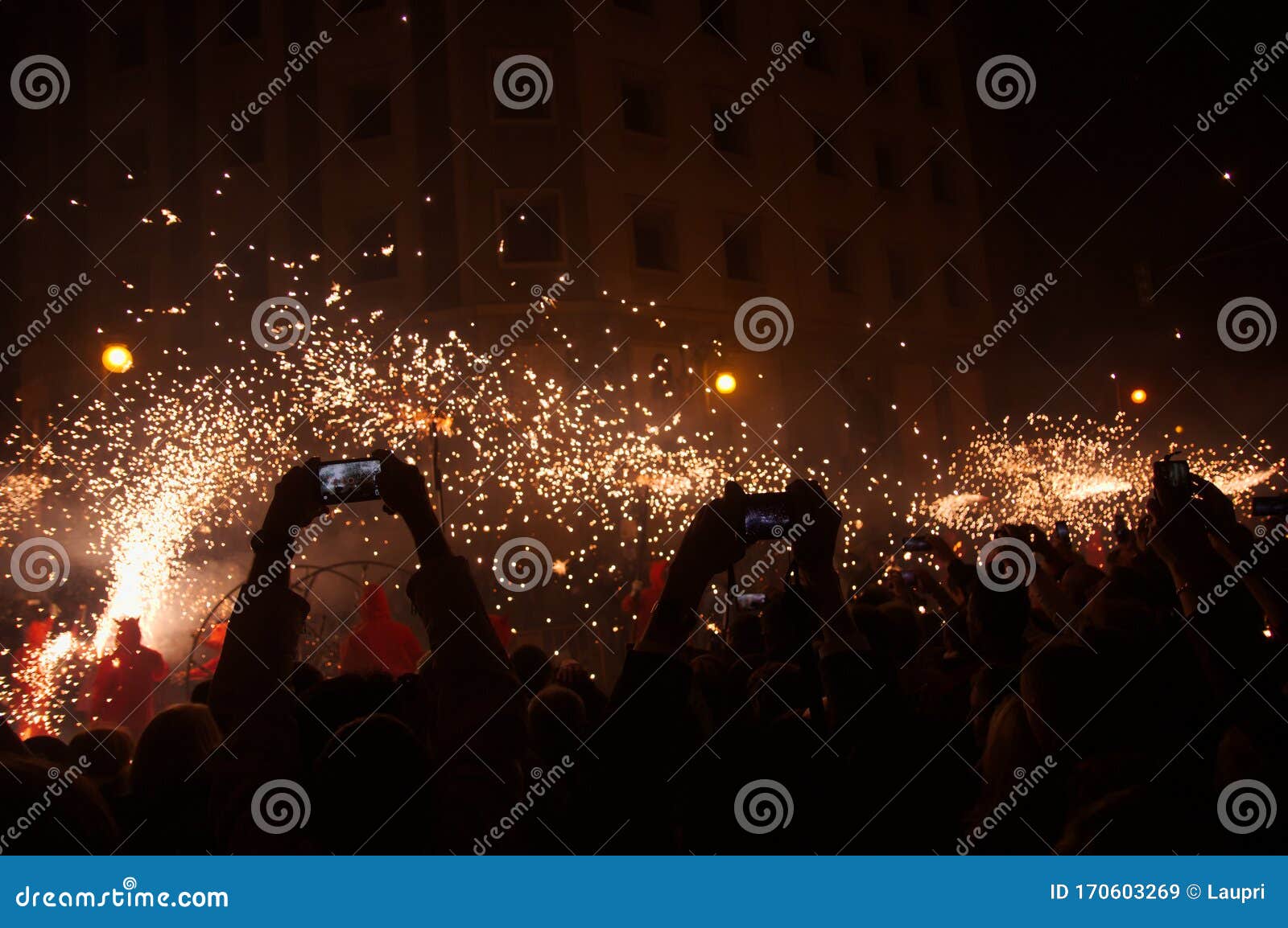 many people watching and photographing the fireworks parade with their mobiles