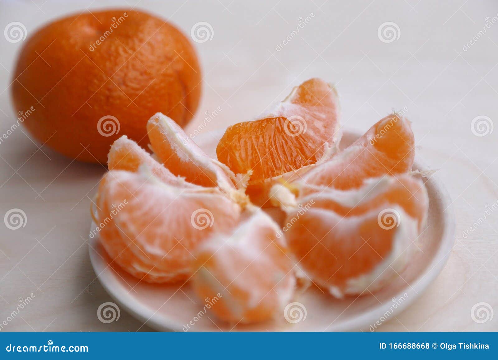 Many Pieces of Mandarin Orange on the Plate and One Mandarin Fruit