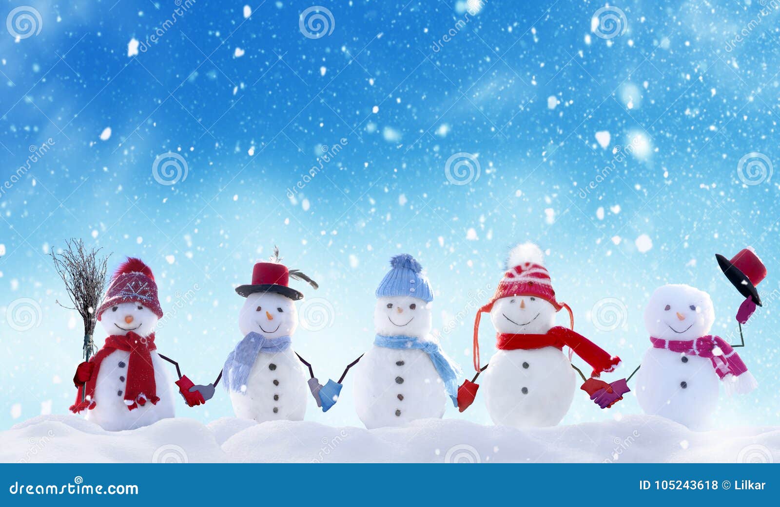 many snowmen standing in winter christmas landscape.