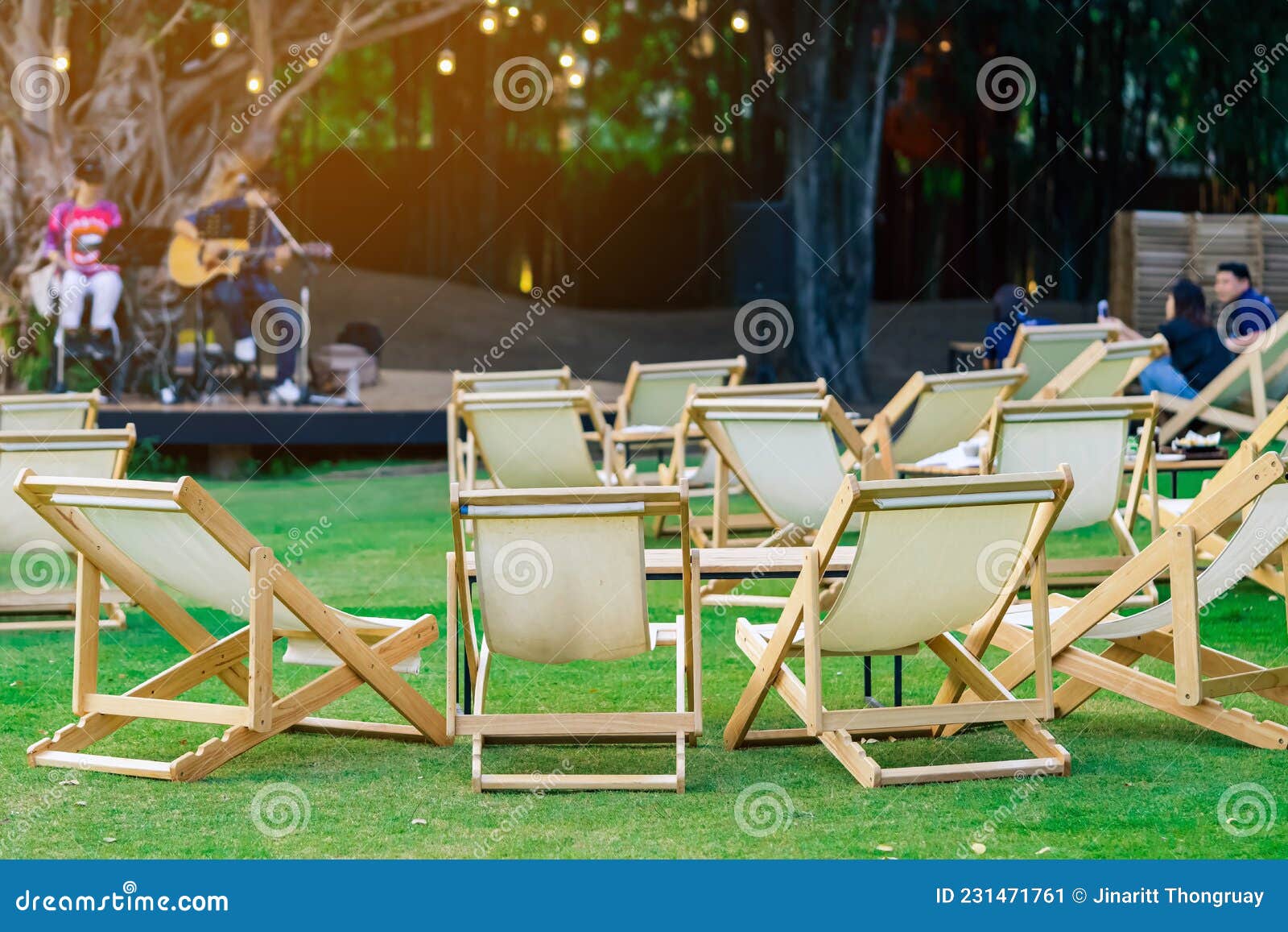 Many White Deck Chairs with Tables for Dinner in Lawn is Surrounded by