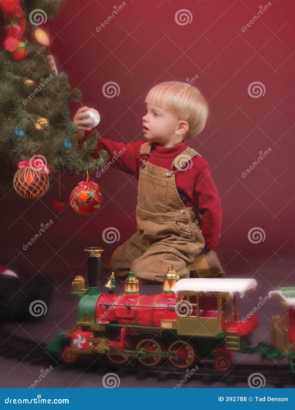 Maravilha do Natal. Rapaz pequeno focalizado em um ornamento do Natal