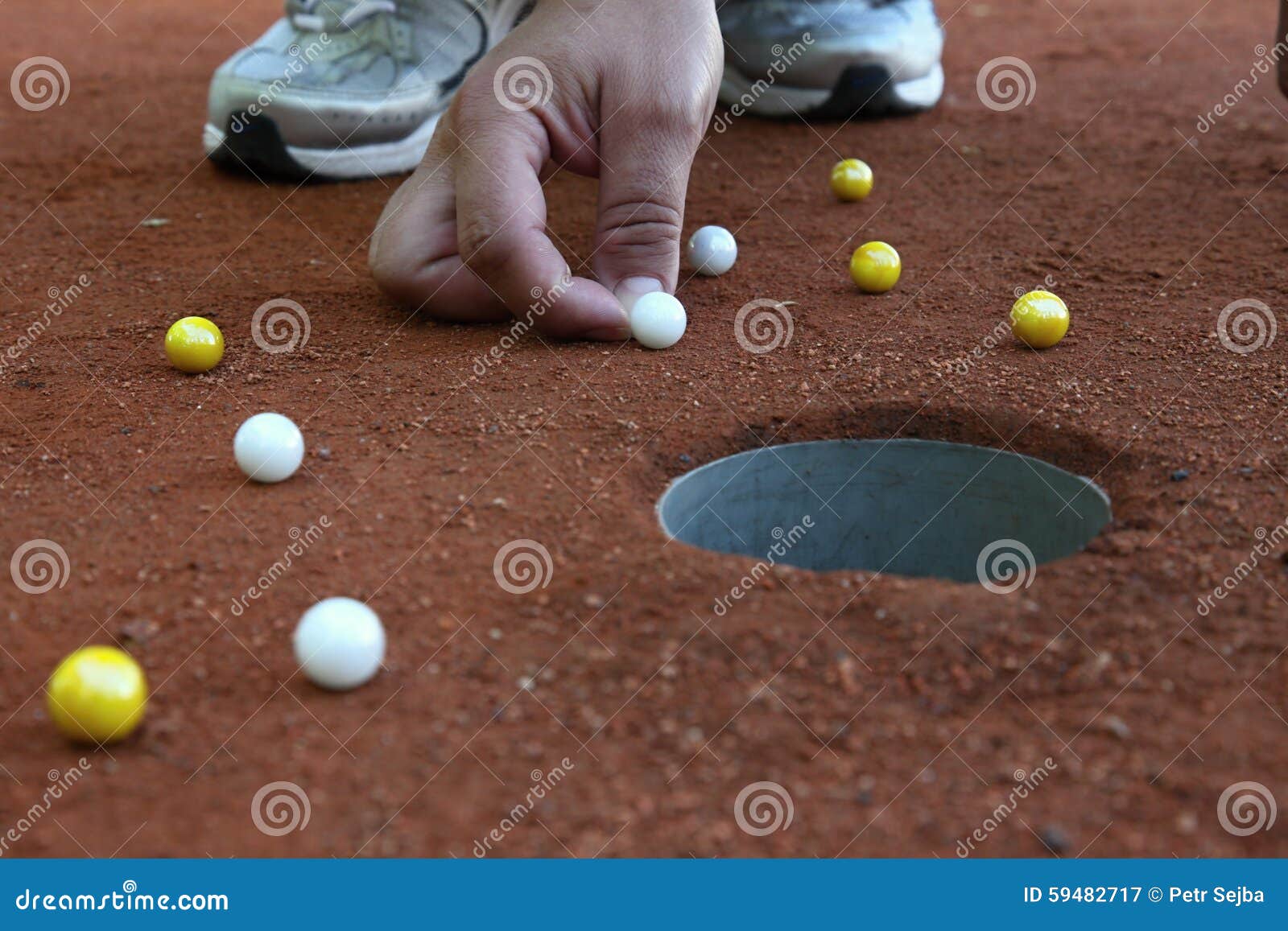 A Marble Player Shooting Marbles To the Hole Stock Image